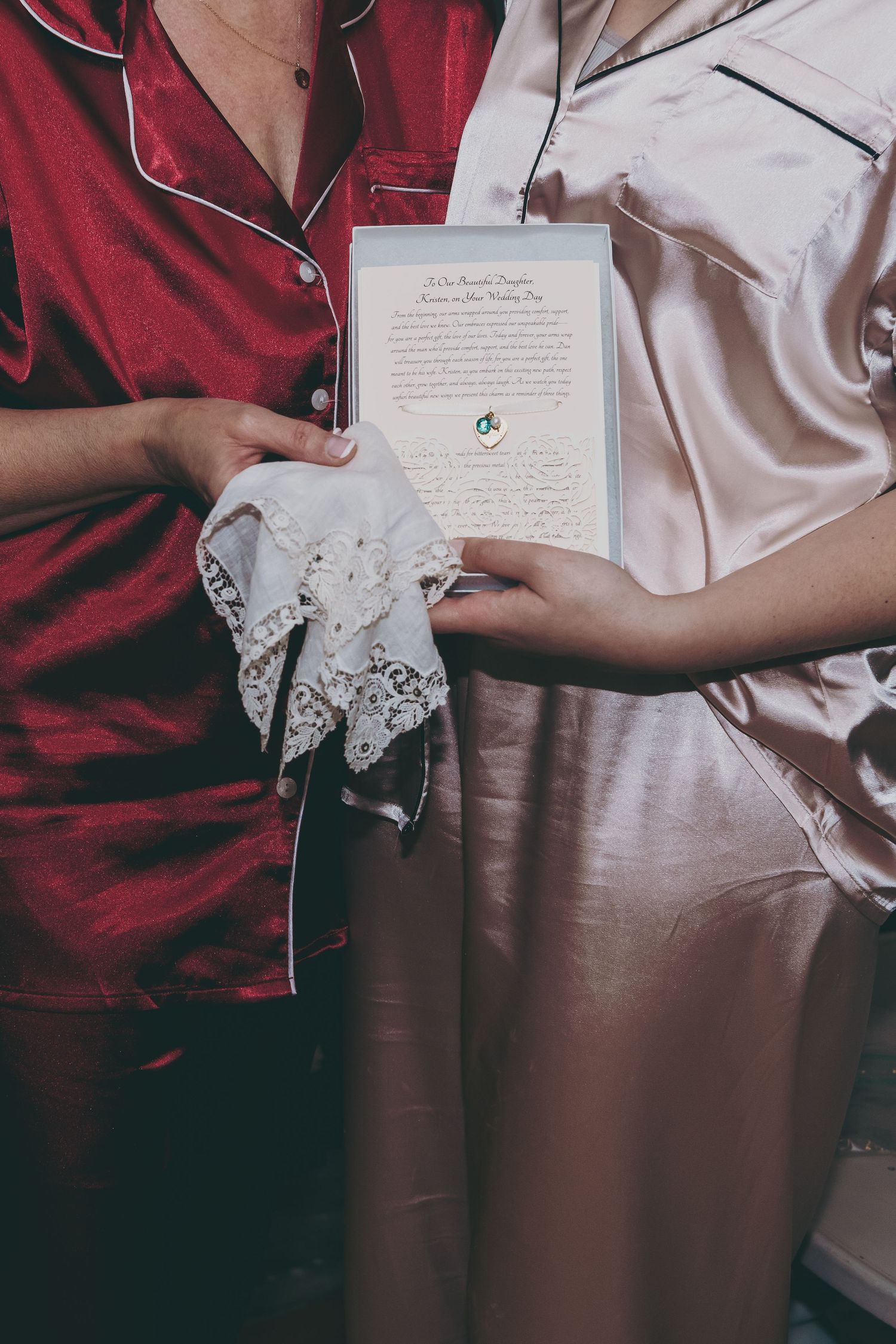Wedding preparations showing hands holding letters and lace details against contrasting fabrics.
