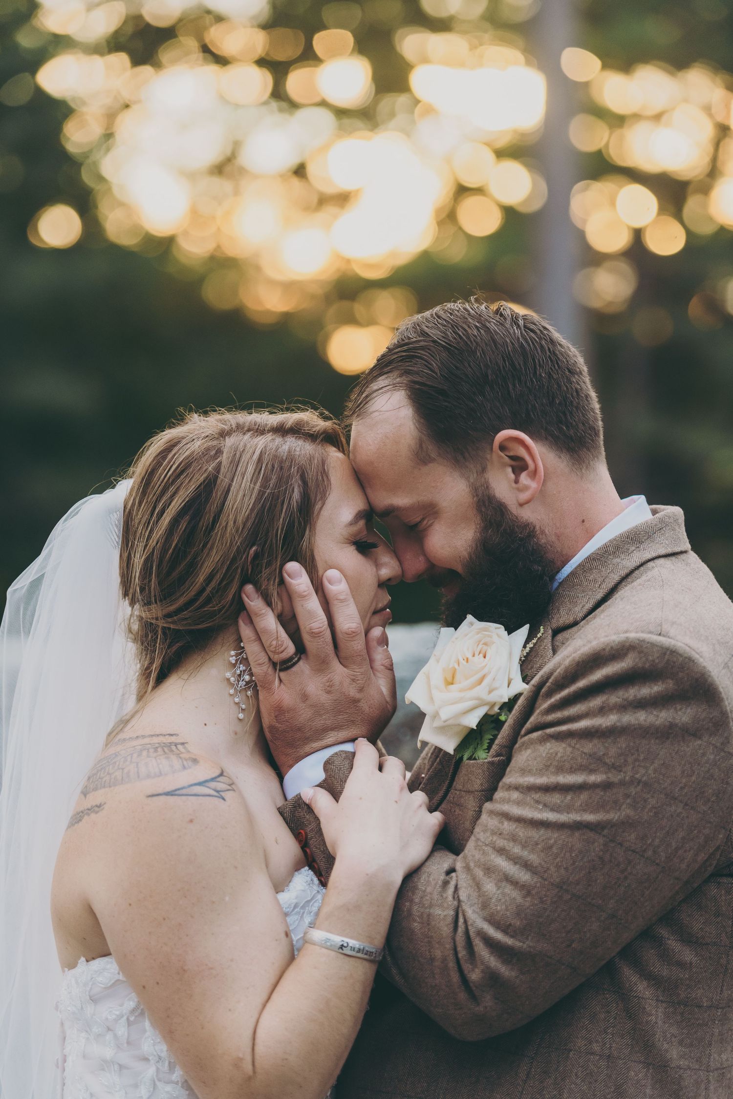 A romantic wedding moment with bokeh lights in the background as newlyweds share an intimate embrace.
