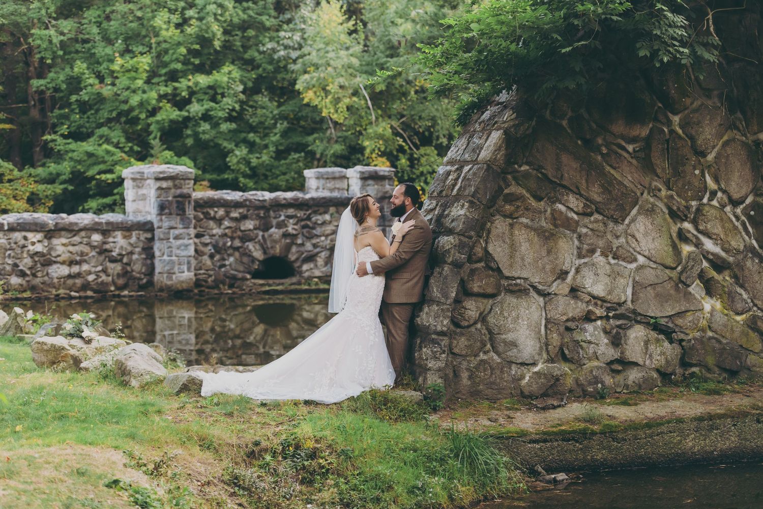 Stone wall ruins in a lush green garden create a romantic outdoor setting for events.