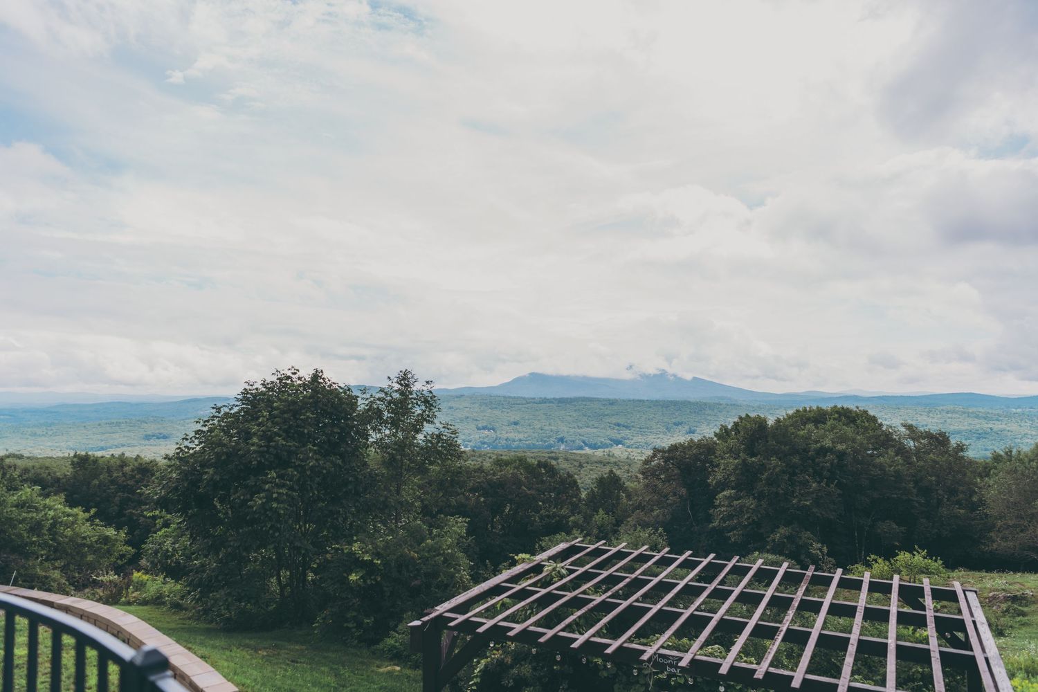 Solar panels being installed on rails across multiple rooftops with scenic mountain views in the background.