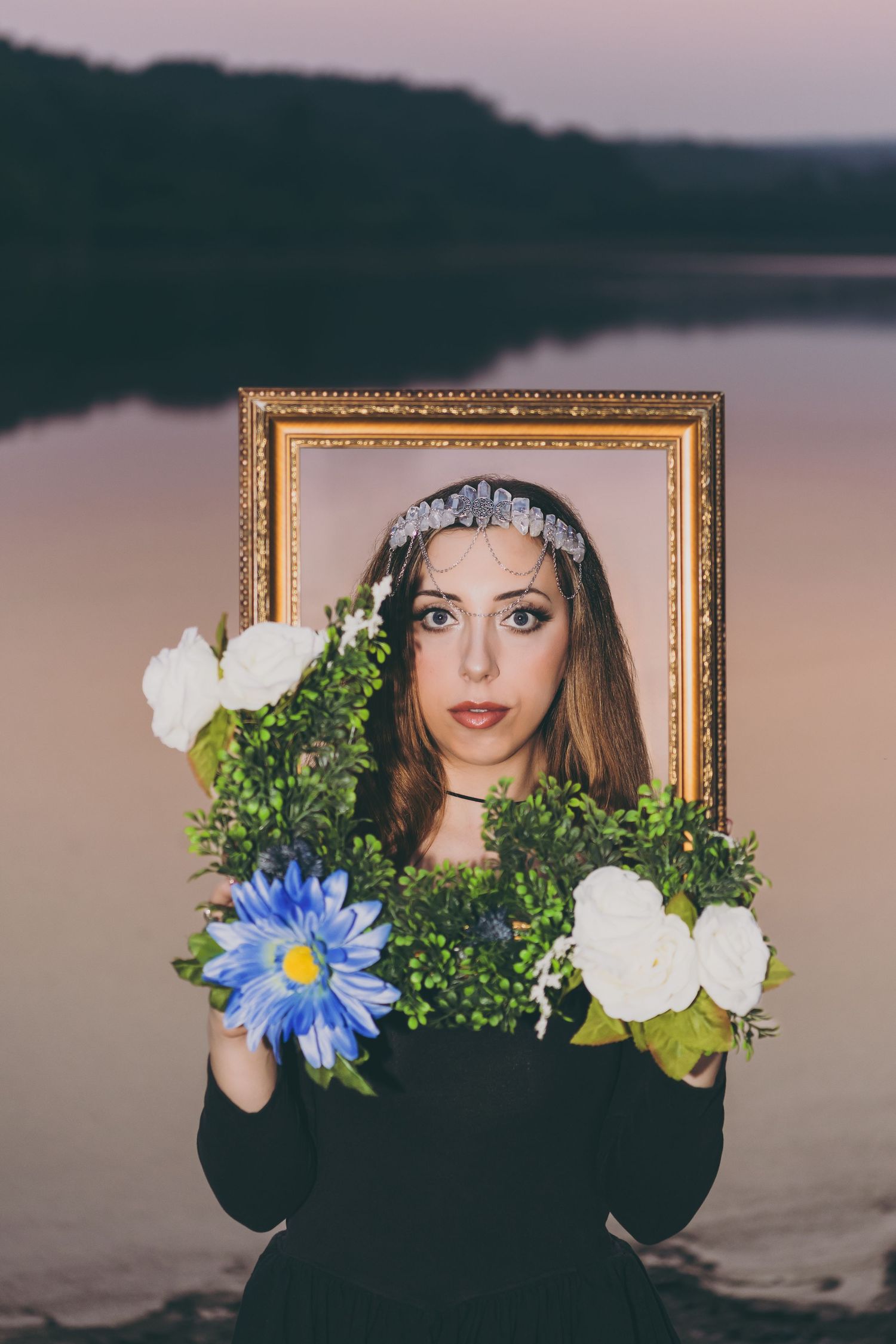 Creative portrait through an ornate gold frame decorated with blue and white flowers.