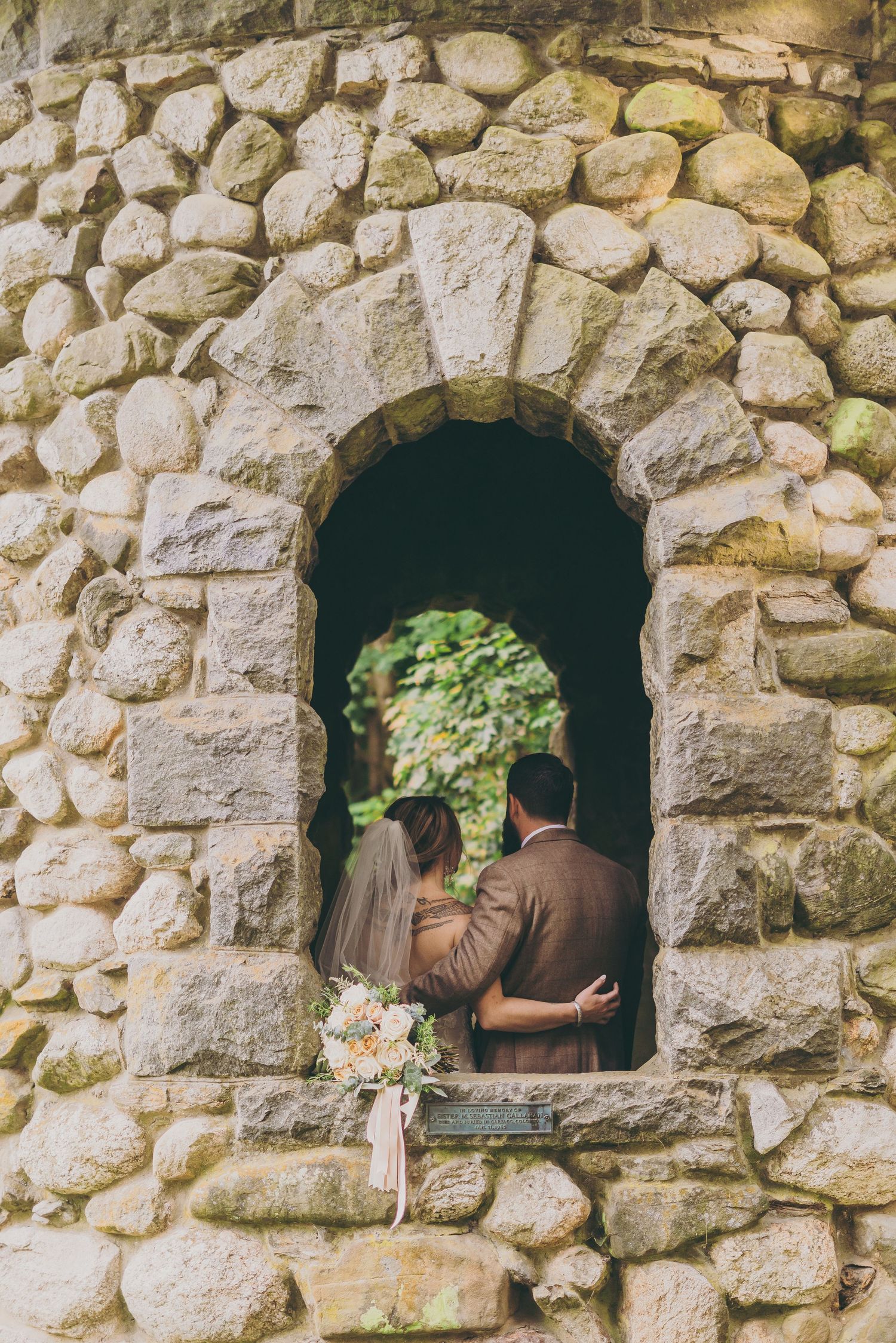 Stone wall with three arched windows or niches displaying rustic architectural detail in sequence.