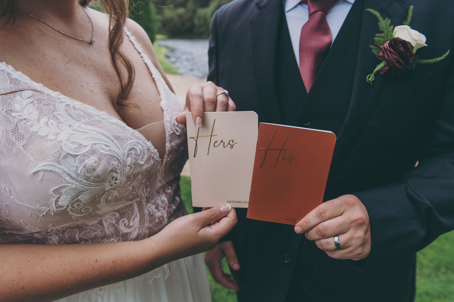 Close-up of vow books being held during outdoor wedding ceremony.