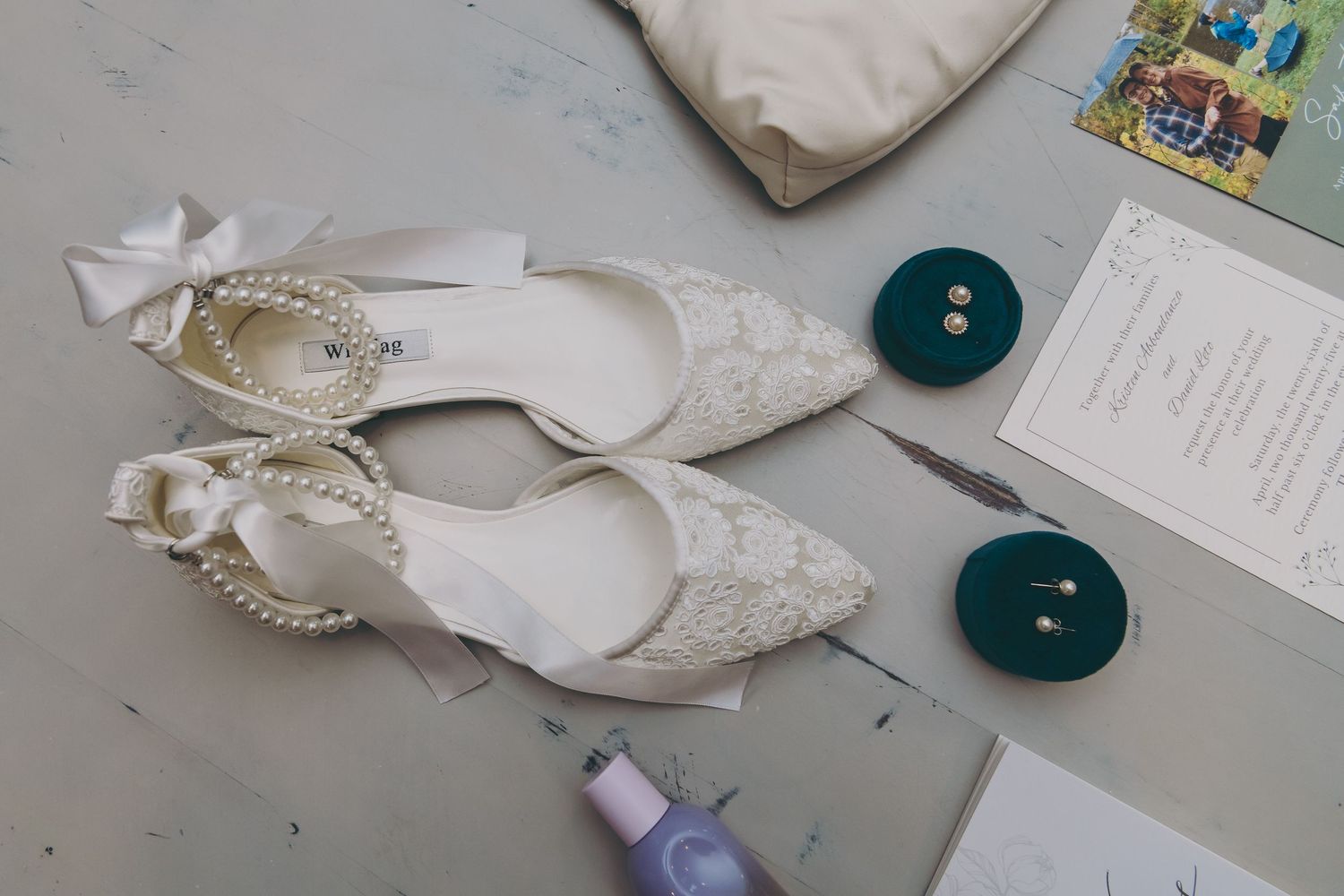 Wedding accessories including white shoes and delicate lace details arranged on light gray surface.