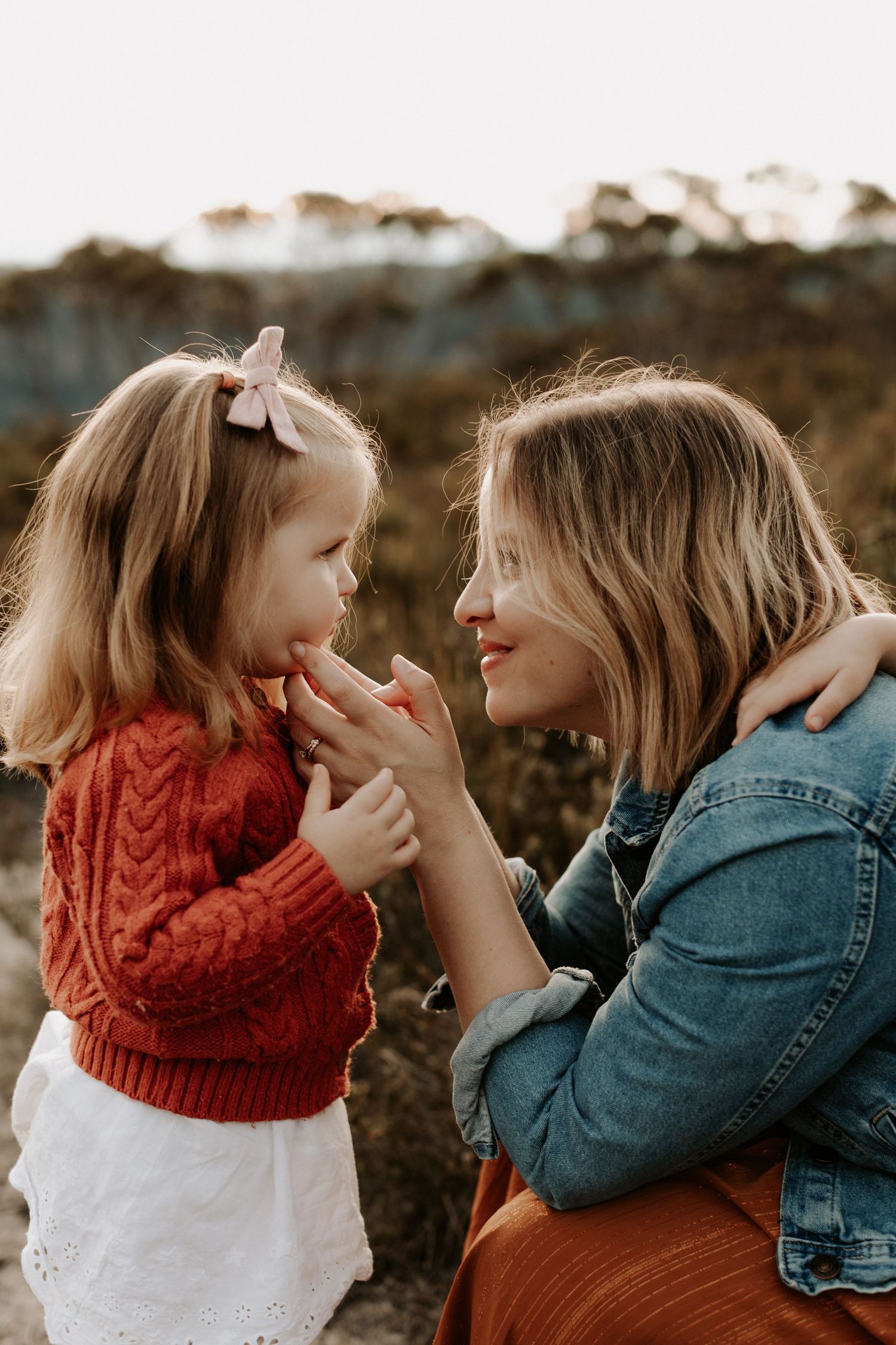 A mother cupping her little girls face in her hands in the Blue Mountains