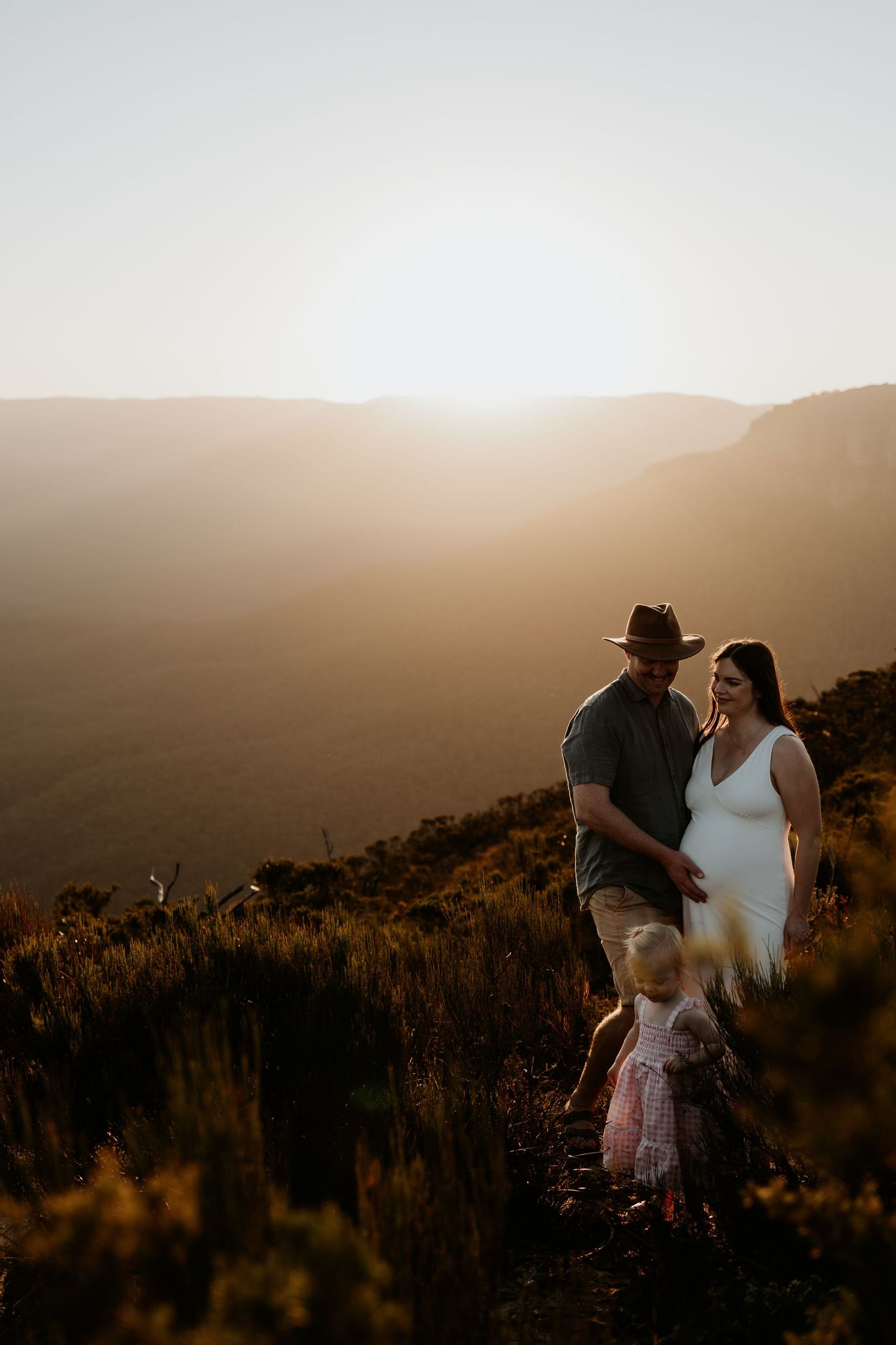 The sun setting on a family with their little girl walking through nature in the Blue Mountains