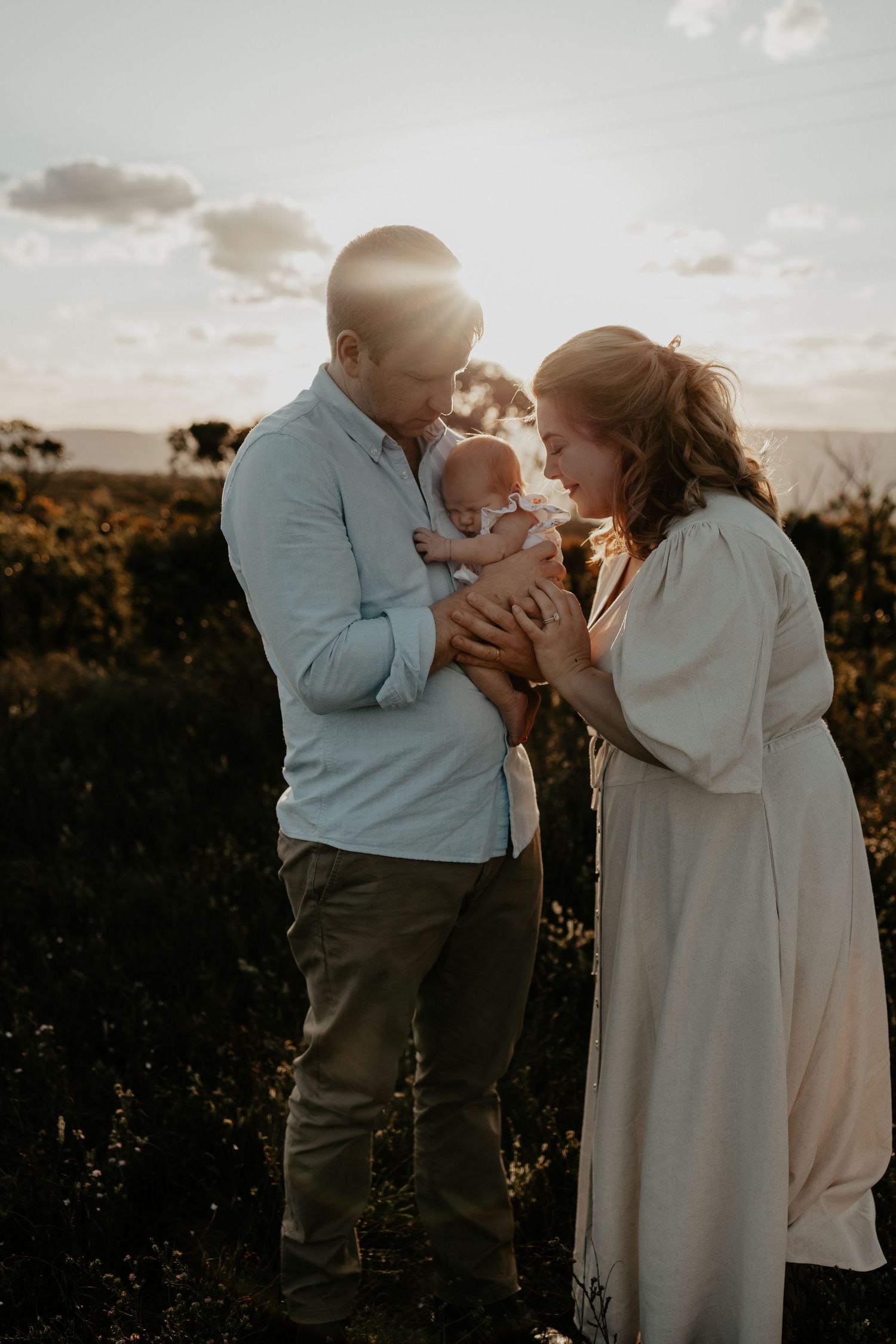 Parents embracing their new baby in the Blue Mountains in the golden sunset