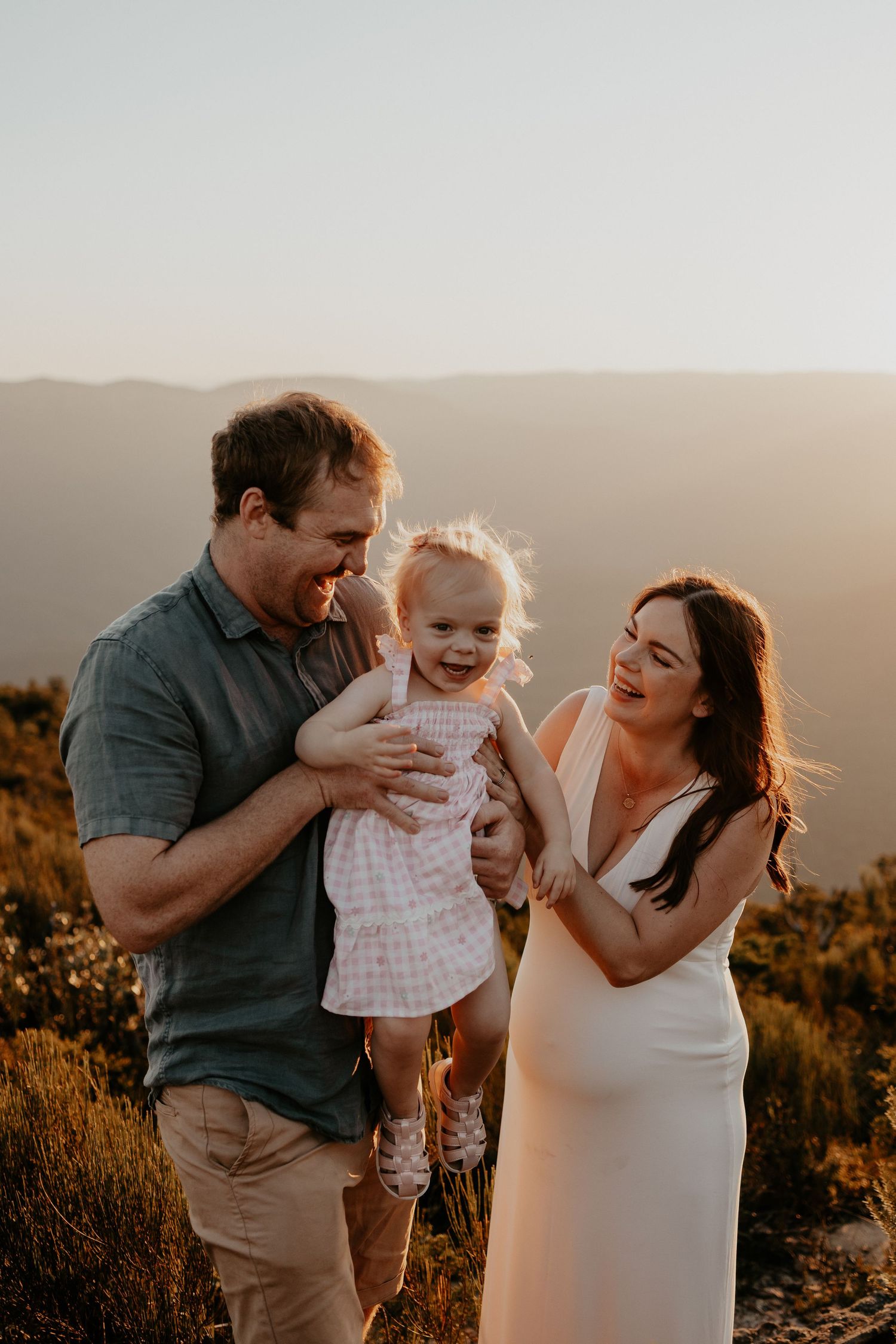 The sun setting on a family with their little girl walking through nature in the Blue Mountains