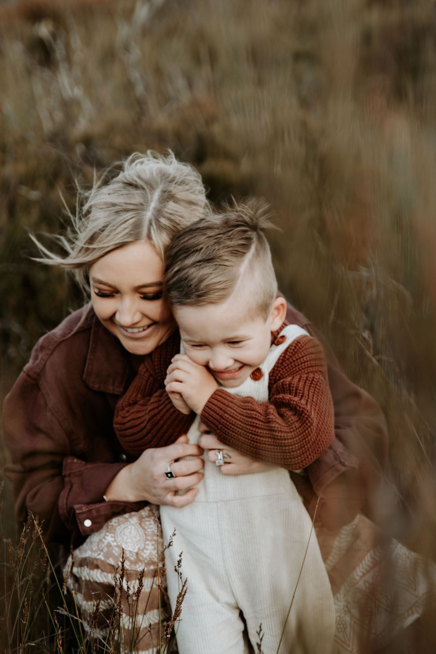 A mother embracing her son surrounded by the wild grass of the Blue Mountains