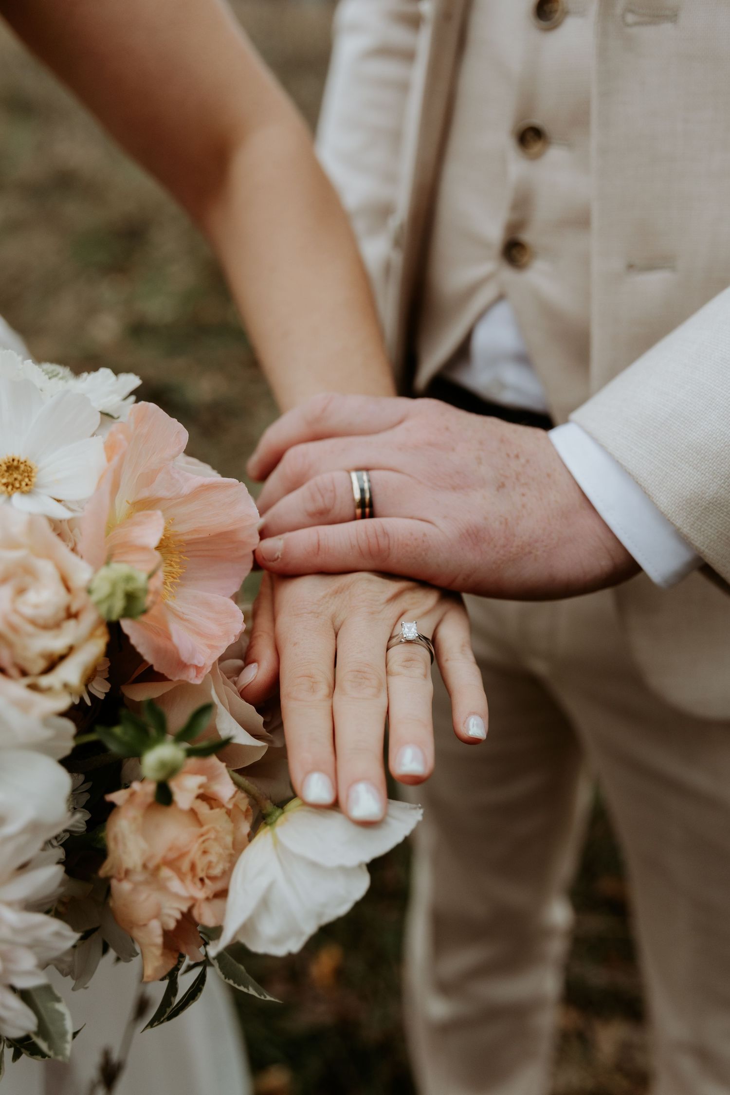 A bride and groom showing off their wedding rings