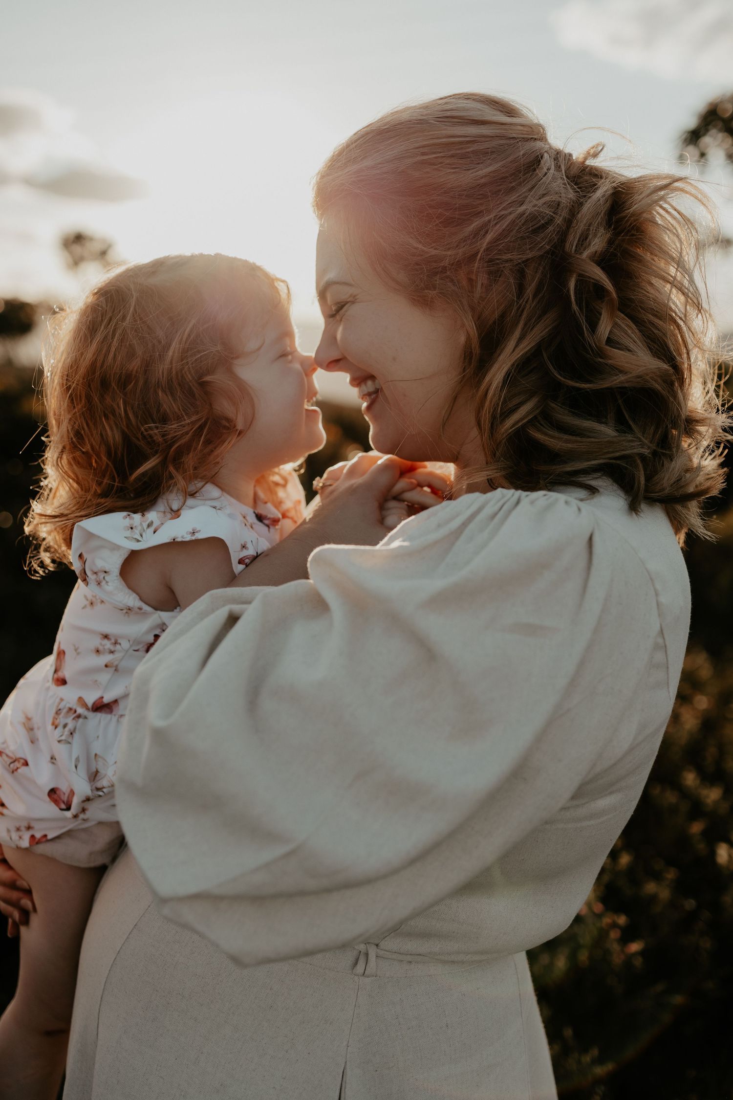 A mother and daughter rubbing noses with the golden light shining in the Blue Mountains