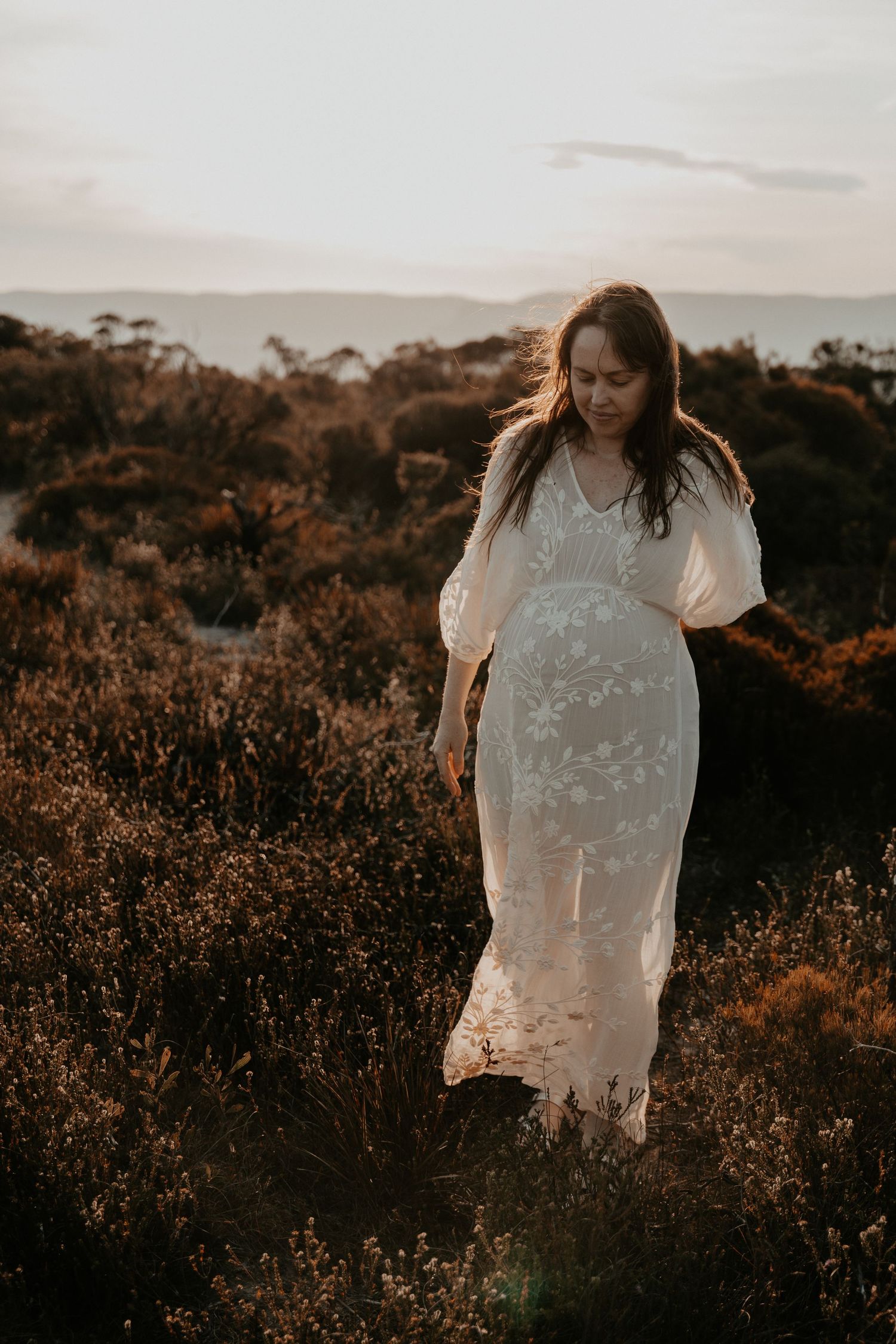 A maternity photo of a pregnant lady walking through the native plants in the Blue Mountains