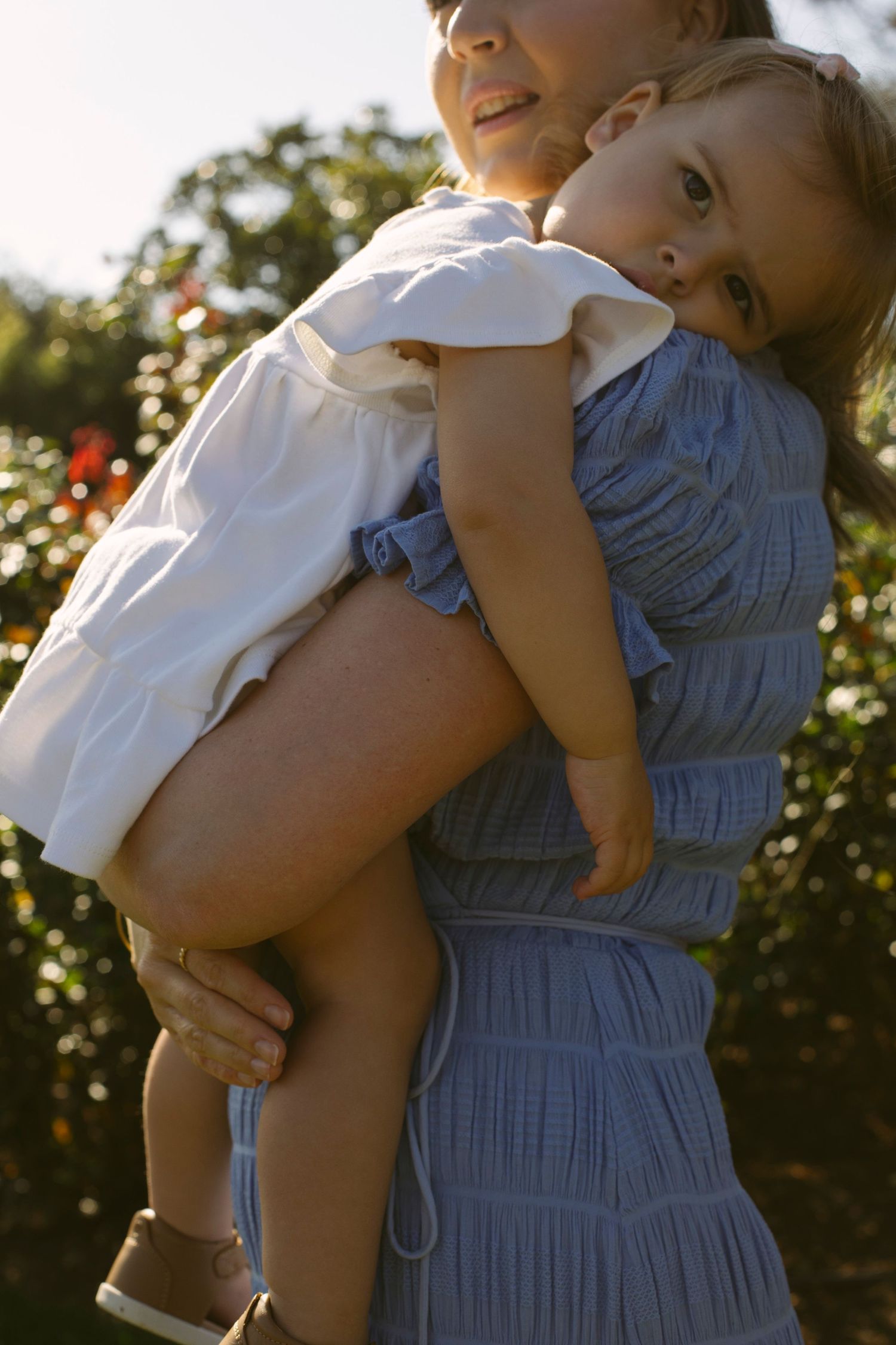 Toddler in mothers arms during motherhood photoshoot
