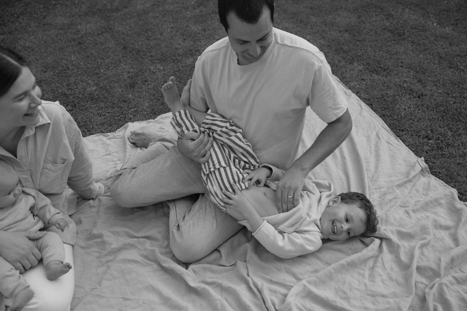 Family playing on picnic blanket