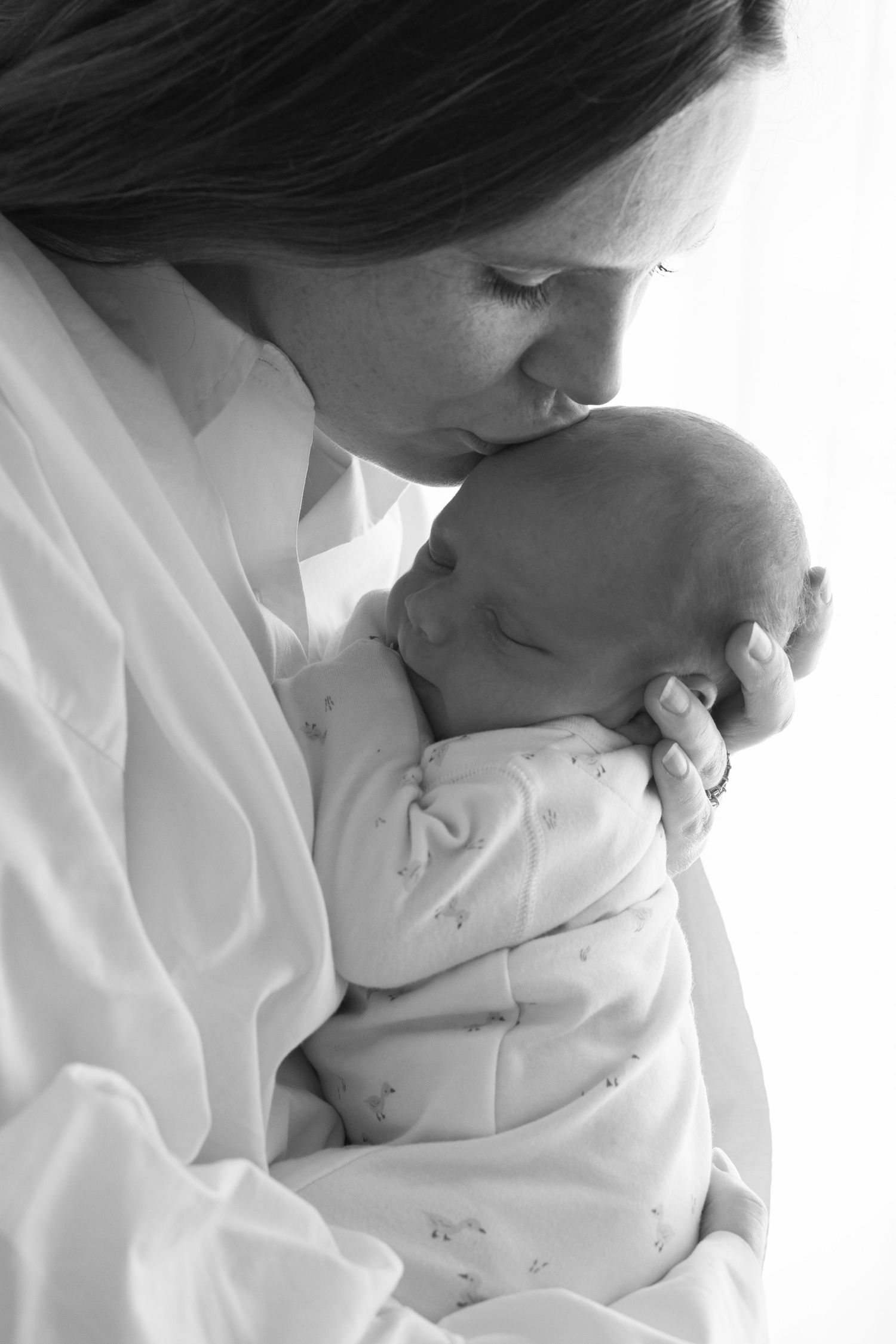 Mum kissing newborn baby