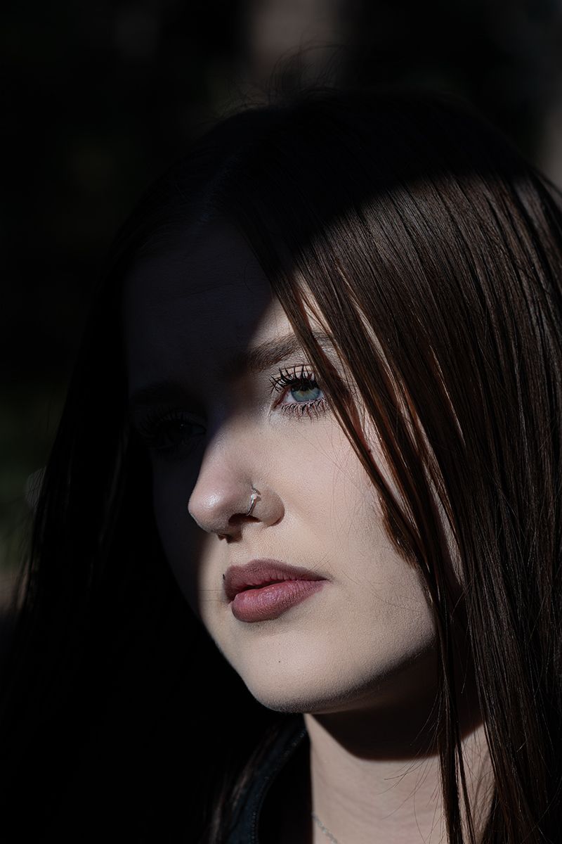 Dark moody portrait series showing close-up facial features with dramatic shadows and dark lipstick.