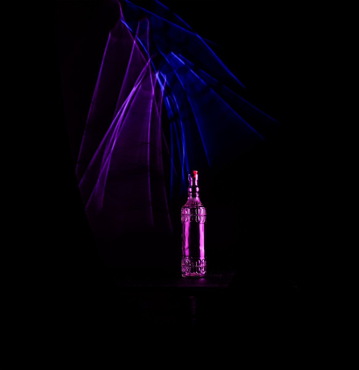 Abstract purple and blue light trails create a dynamic pattern against a dark background in a sequence of frames.