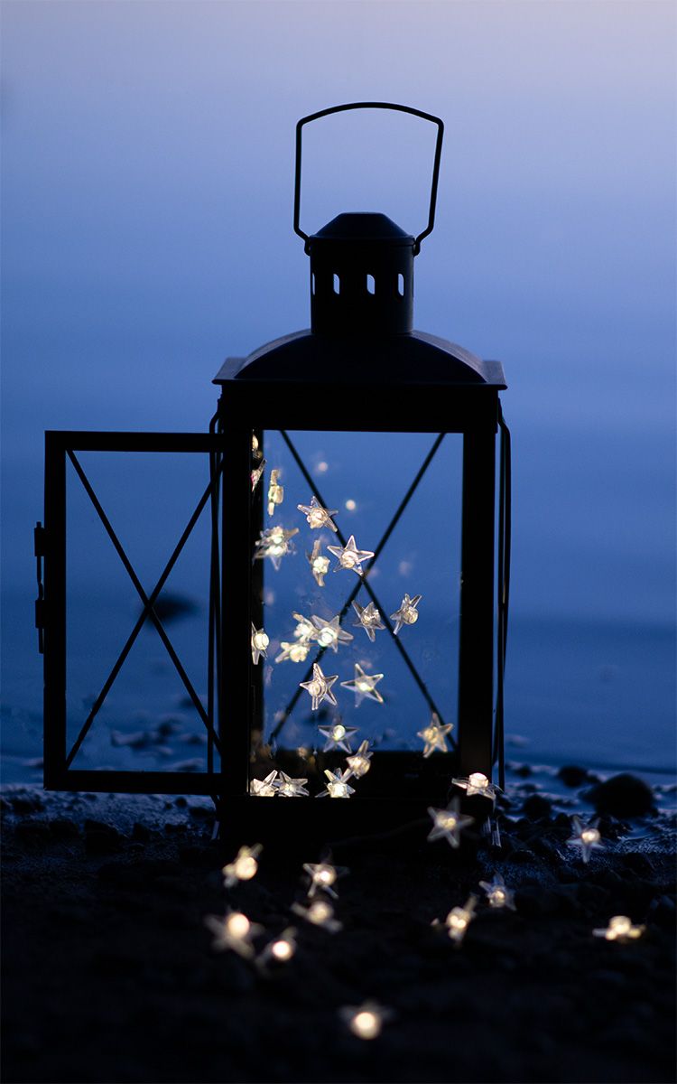 Decorative lanterns with star-shaped lights create a magical silhouette against a dusky blue background.