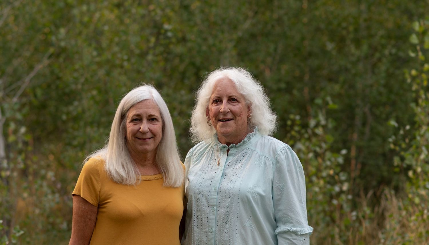 Senior loved ones enjoy spending quality time together outdoors surrounded by vibrant autumn foliage.