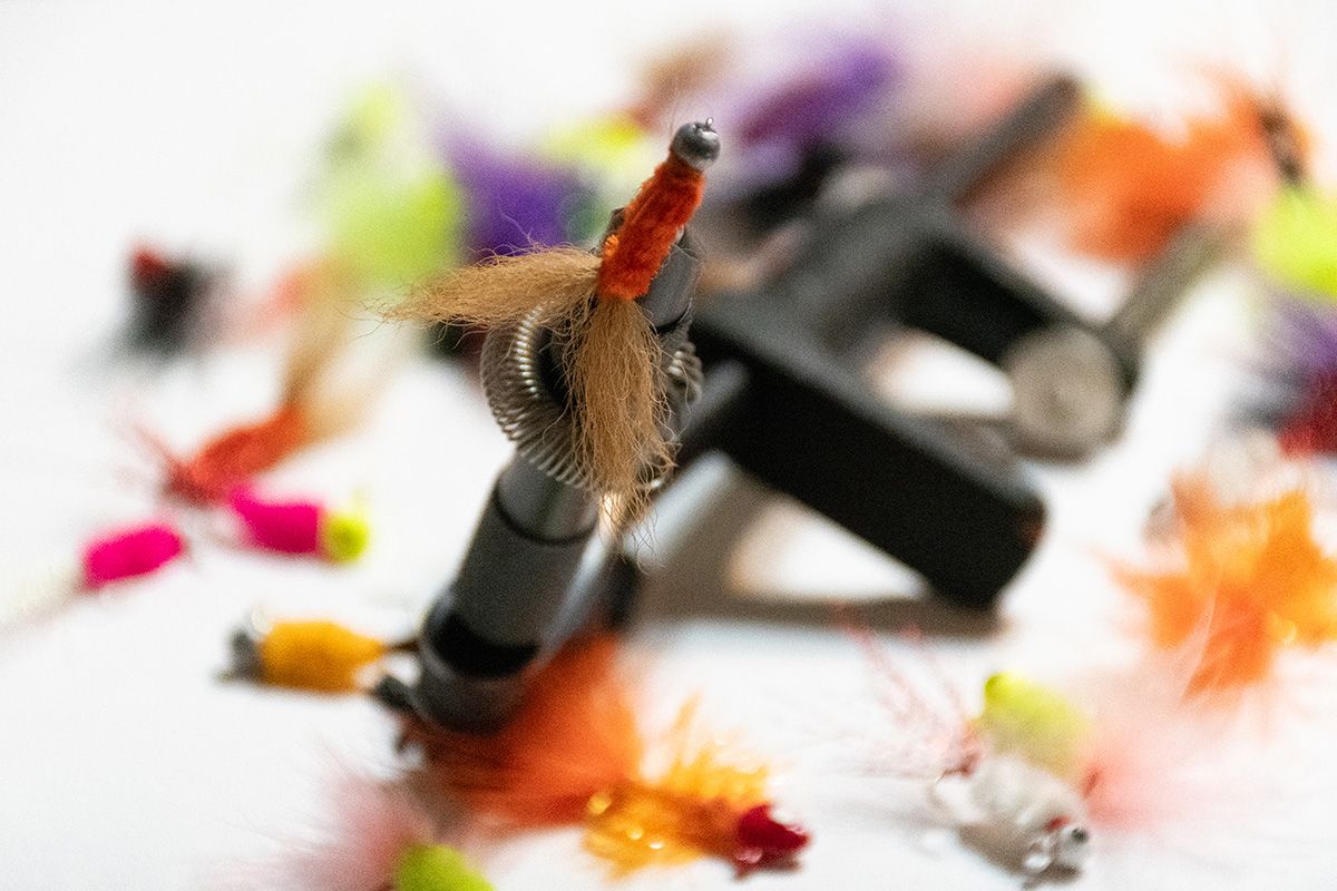 Close-up of colorful fishing flies with selective focus on a white background.