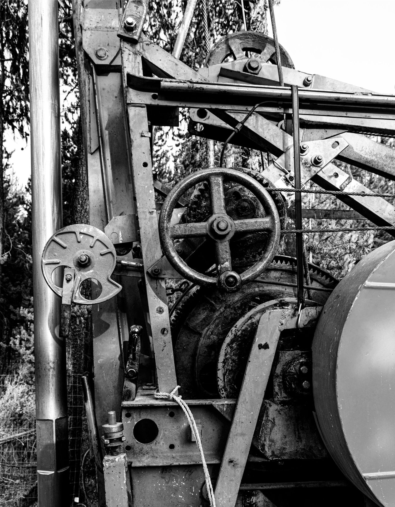 Close-up of antique machinery controls showing manual wheel and mechanical linkages.