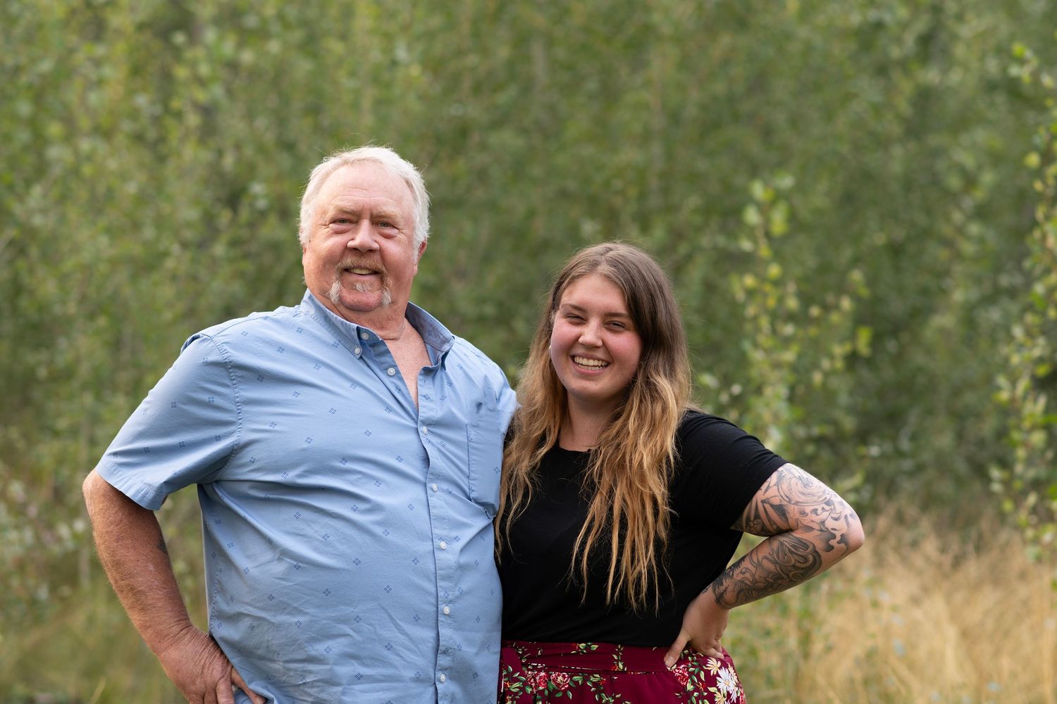 A father-daughter portrait series in an outdoor field with tall grass and natural lighting.