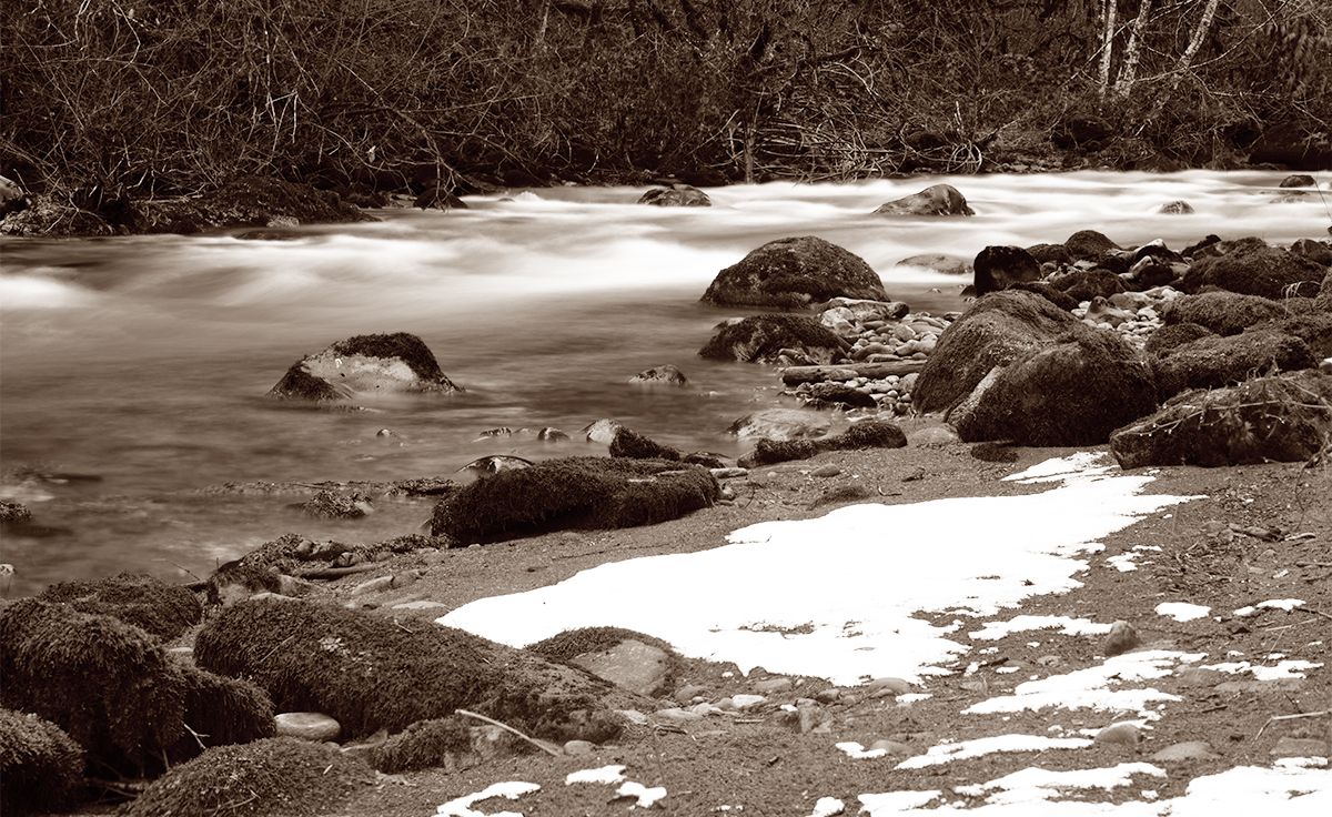 Black and white landscape of rushing water and rocks in a mountain stream.