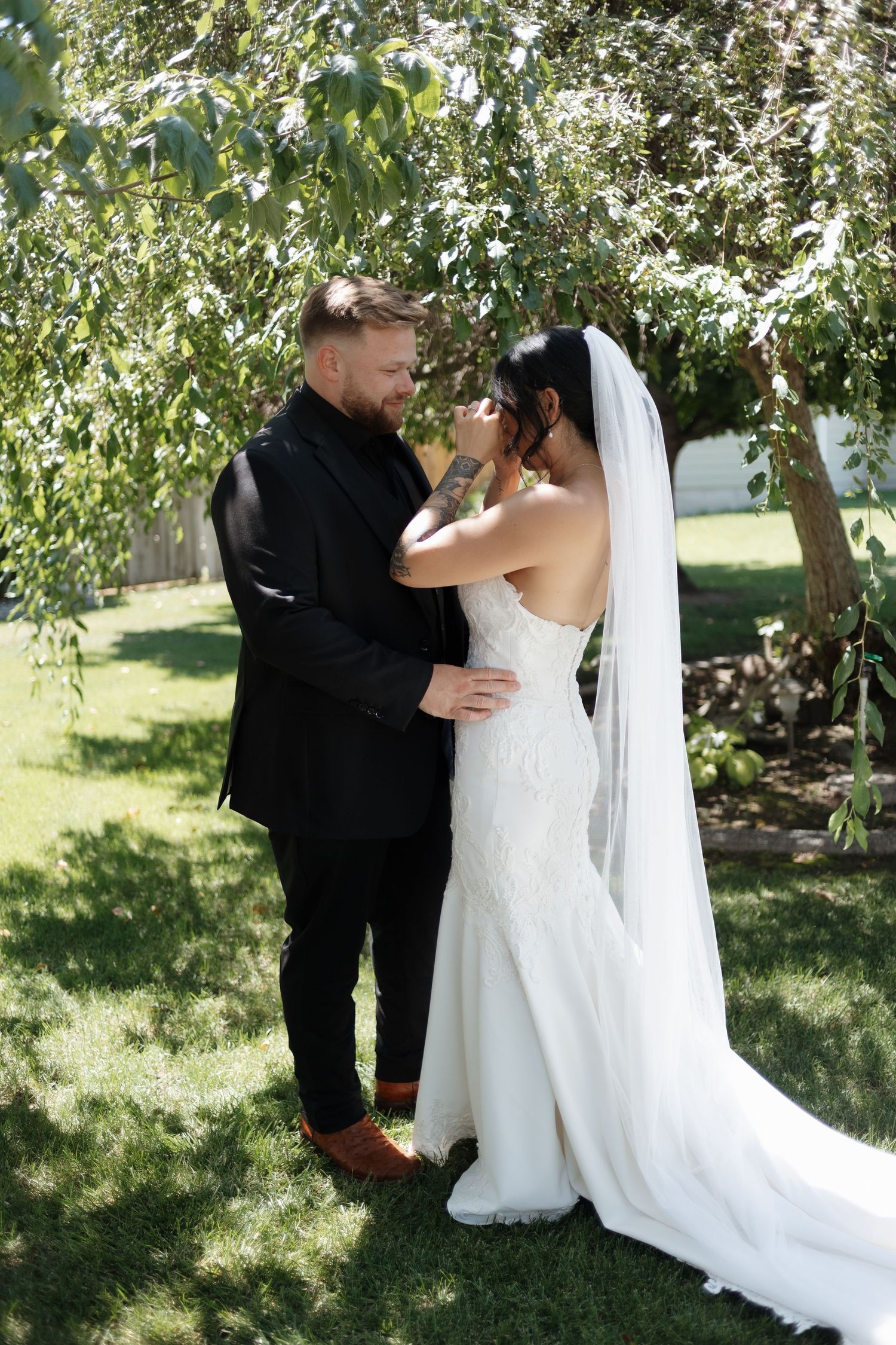 A couple shares a romantic moment in an apple orchard during their wedding photoshoot.