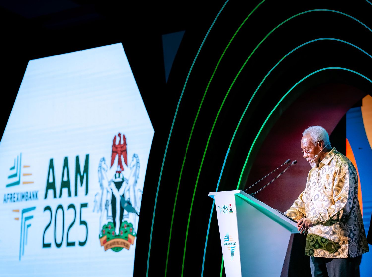 Event space with green lighting effects and digital displays showing 2025 branding.