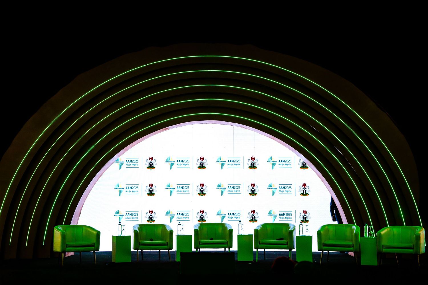 Curved architectural structure with backlit displays and green accent lighting.