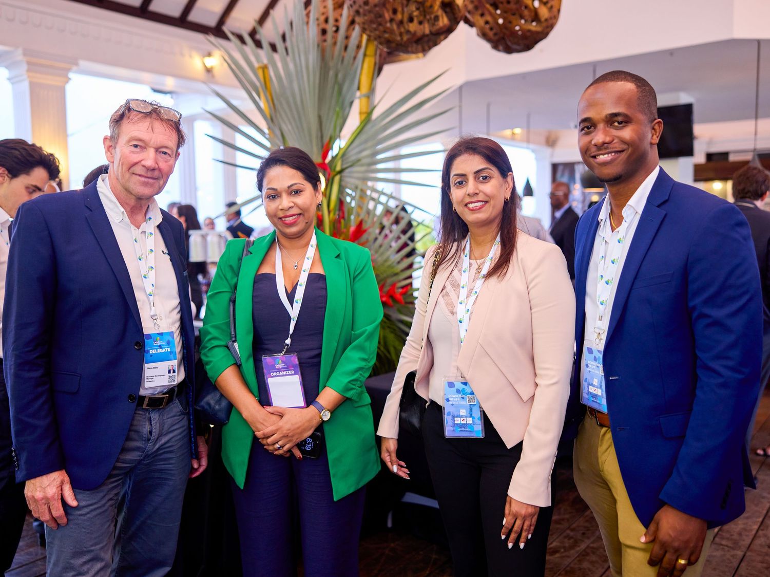 Four professionals wearing conference badges pose together at a Caribbean energy diversity networking event.