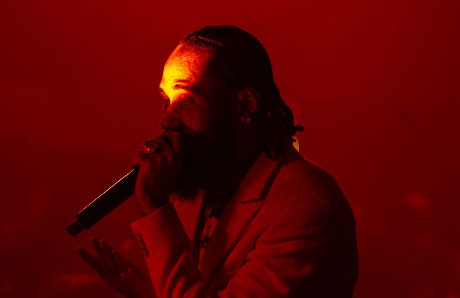 Performance silhouettes against deep red dramatic stage lighting.