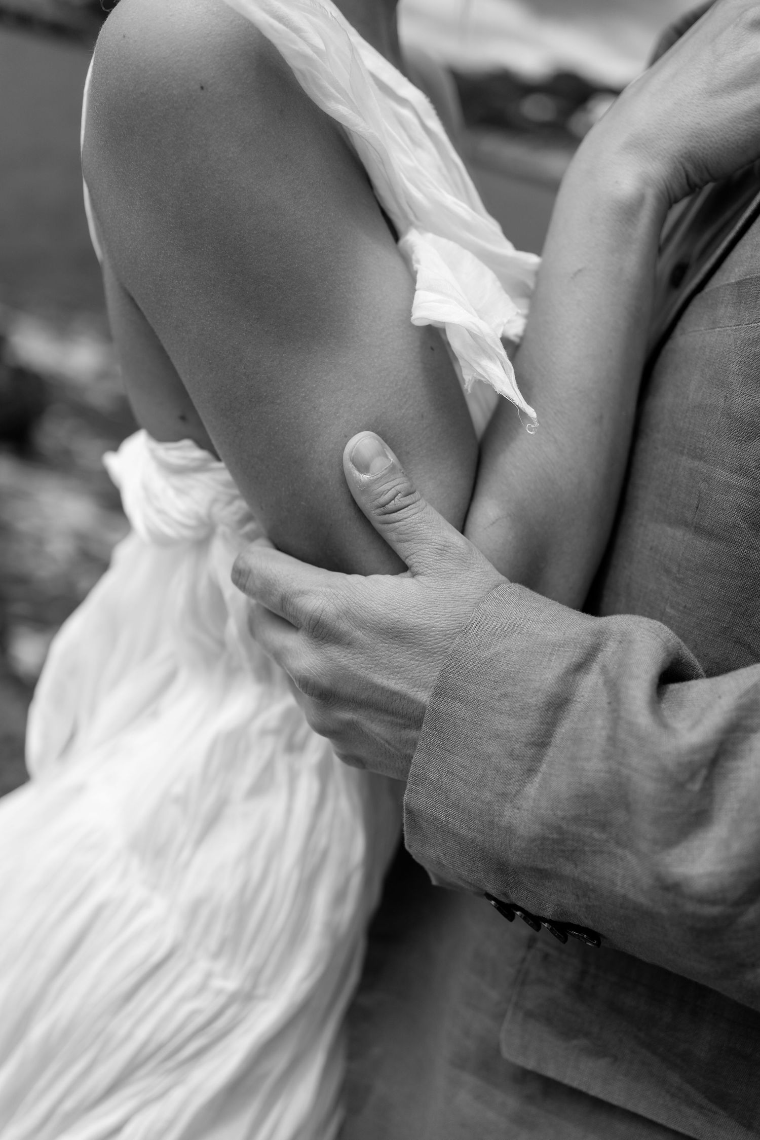 Artistic black and white detail of hands touching fabric.