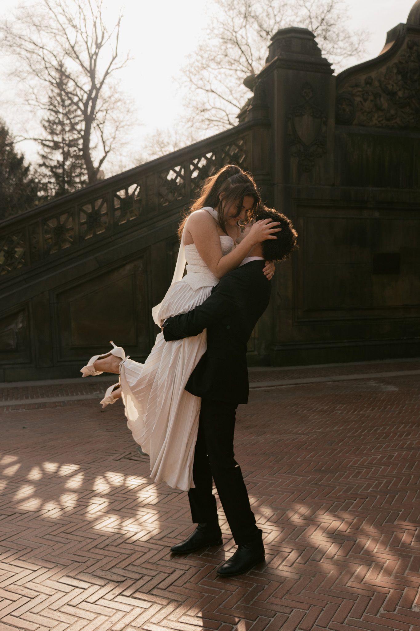 Romantic dance sequence on brick pavement at sunset.