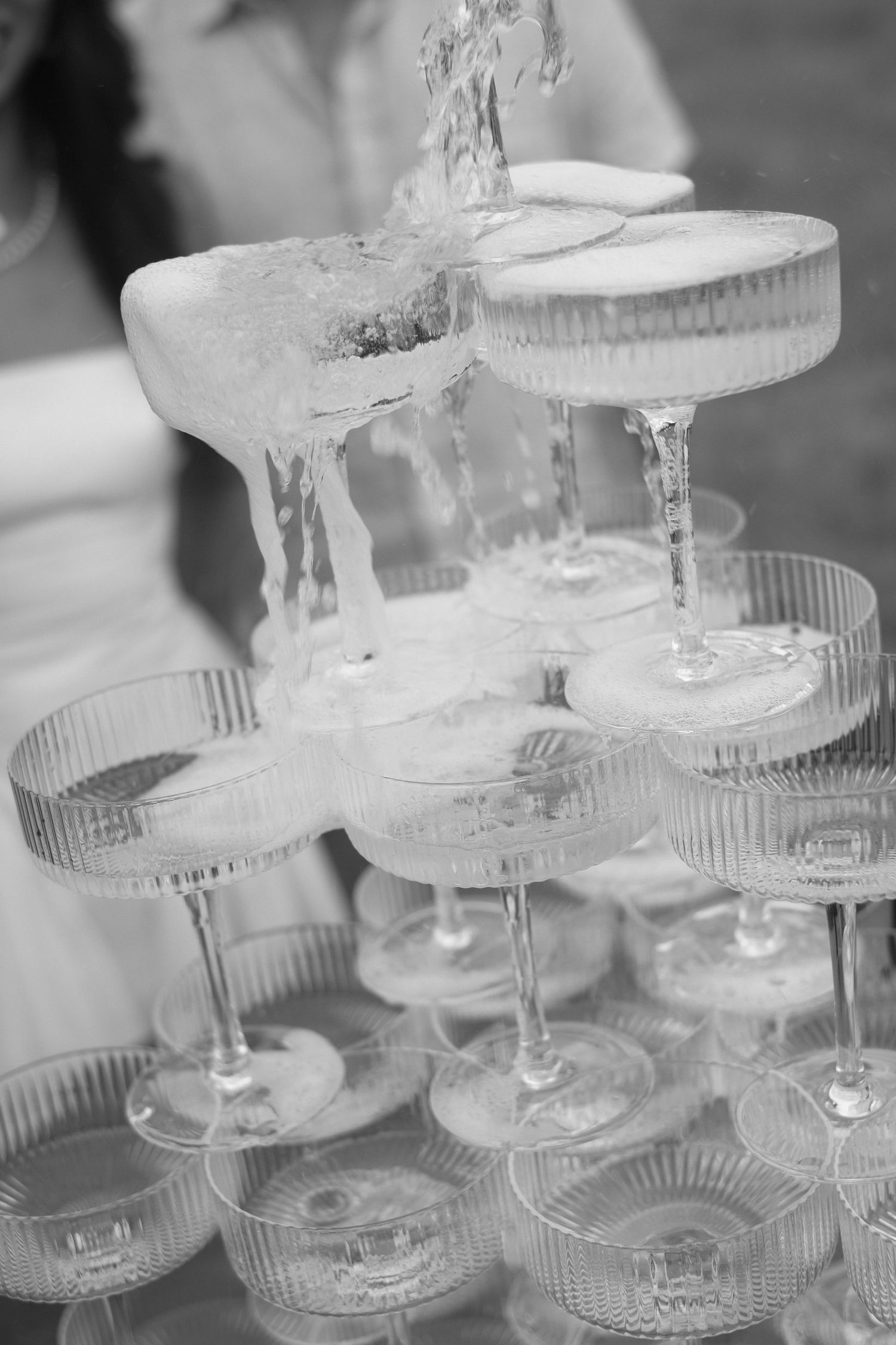 A multi-tiered glass champagne tower display at a wedding reception event.