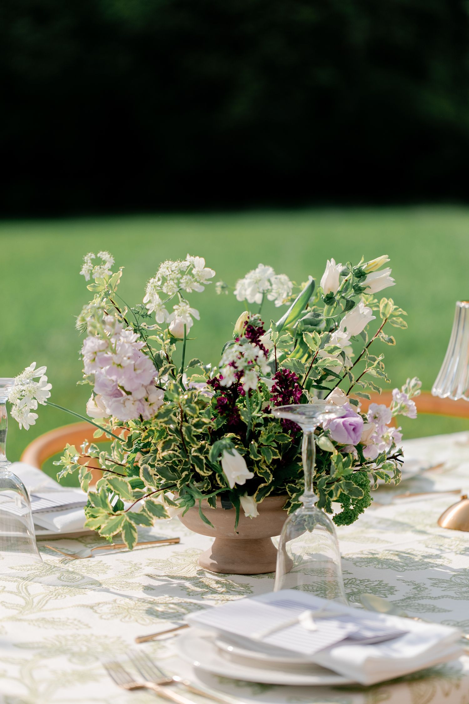An elegant table setting with delicate floral centerpieces and white linens for a garden wedding.