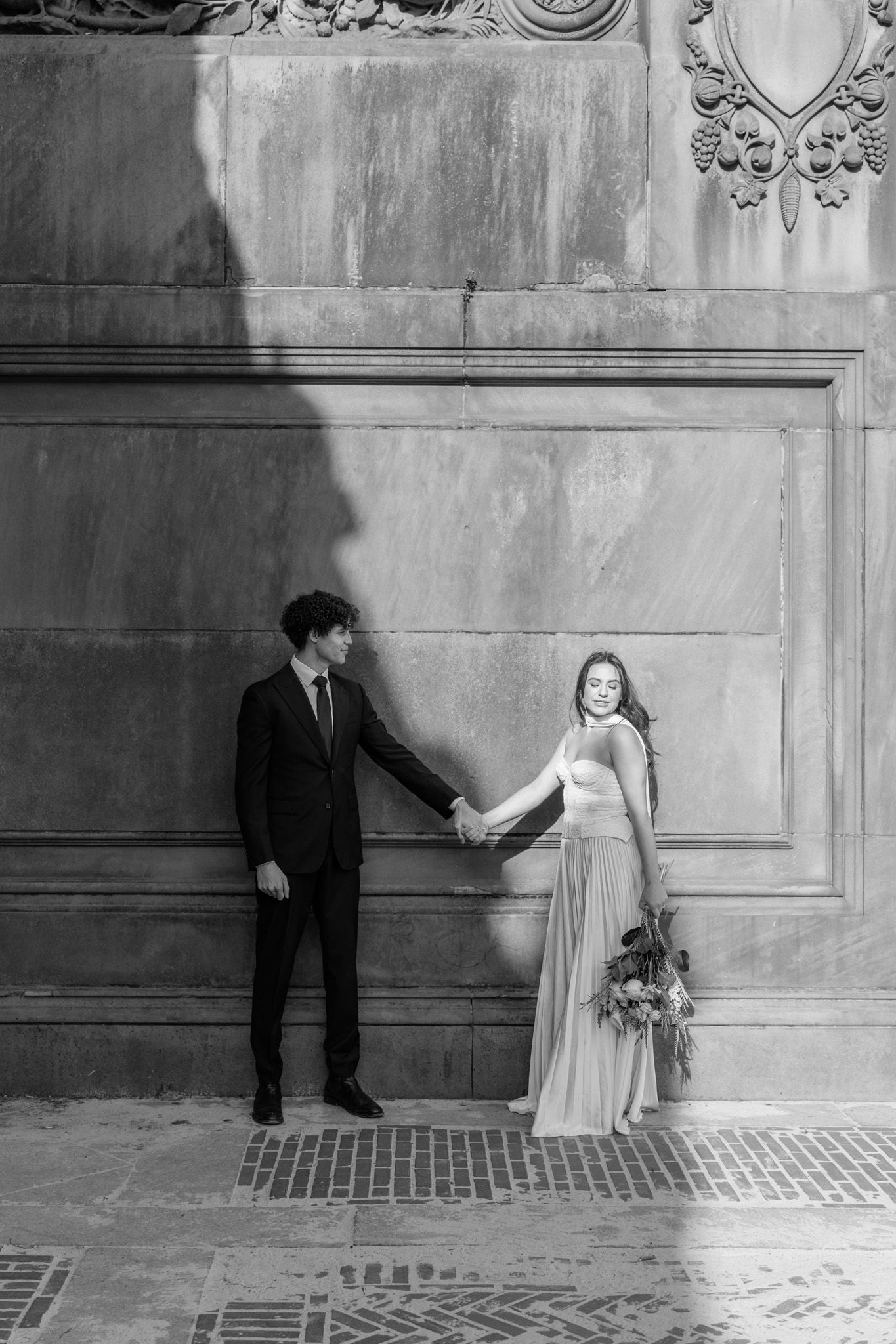 An artistic black and white wedding photo sequence against an ornate wall with dramatic shadows.