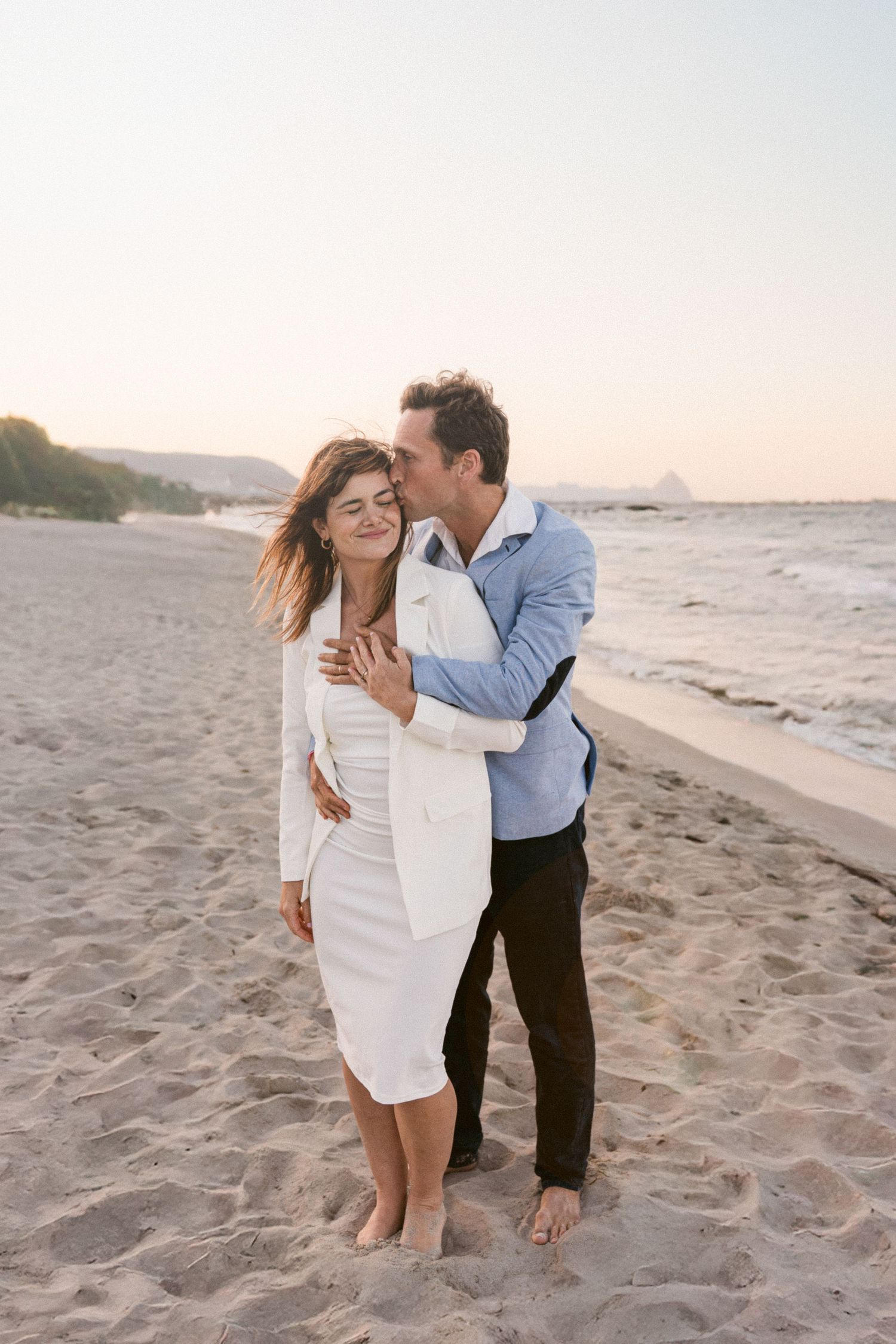 Romantic couple enjoying sunset moments together on sandy beach.
