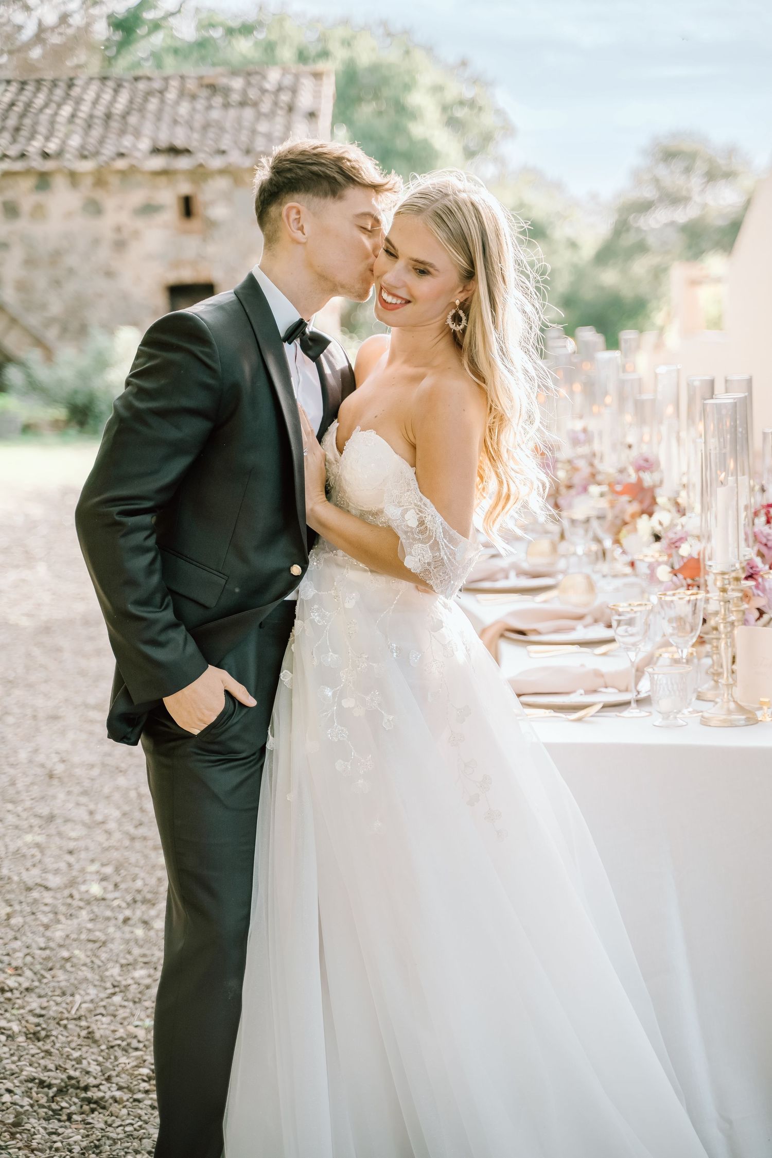 An elegant wedding reception setup with decorated tables and a couple sharing a tender moment.