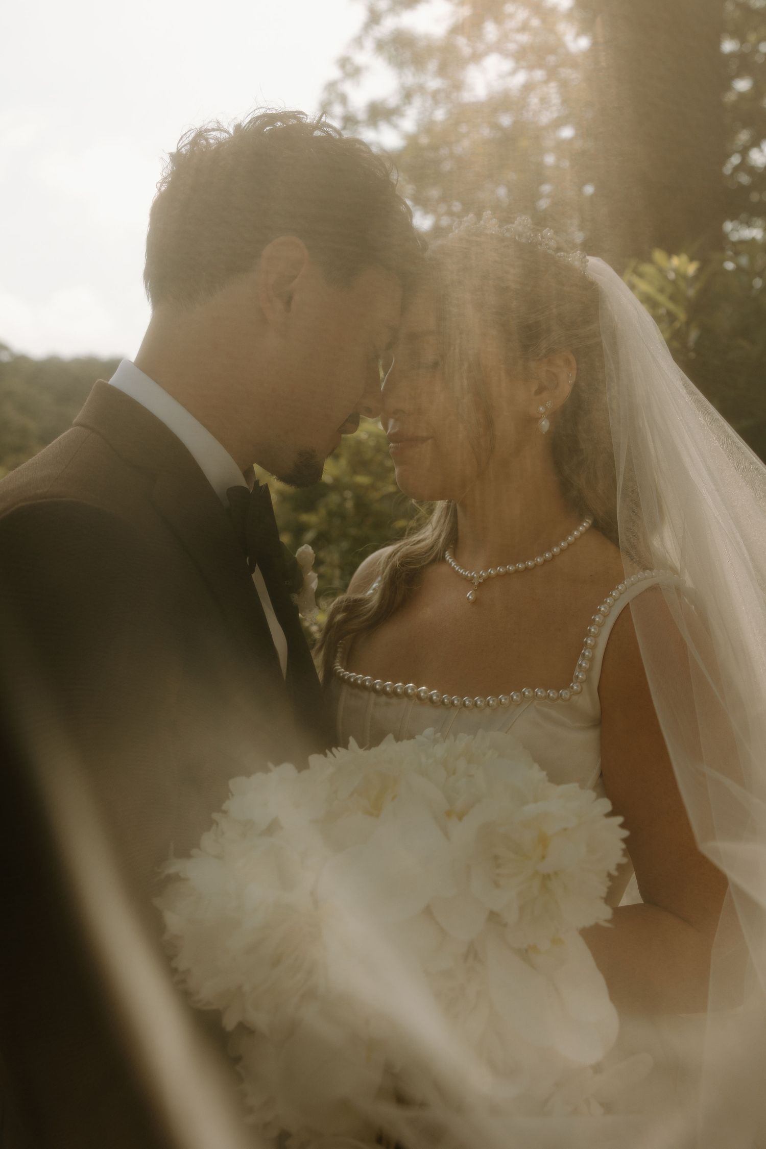 Romantic sunlit wedding portrait sequence capturing intimate moments between newlyweds.