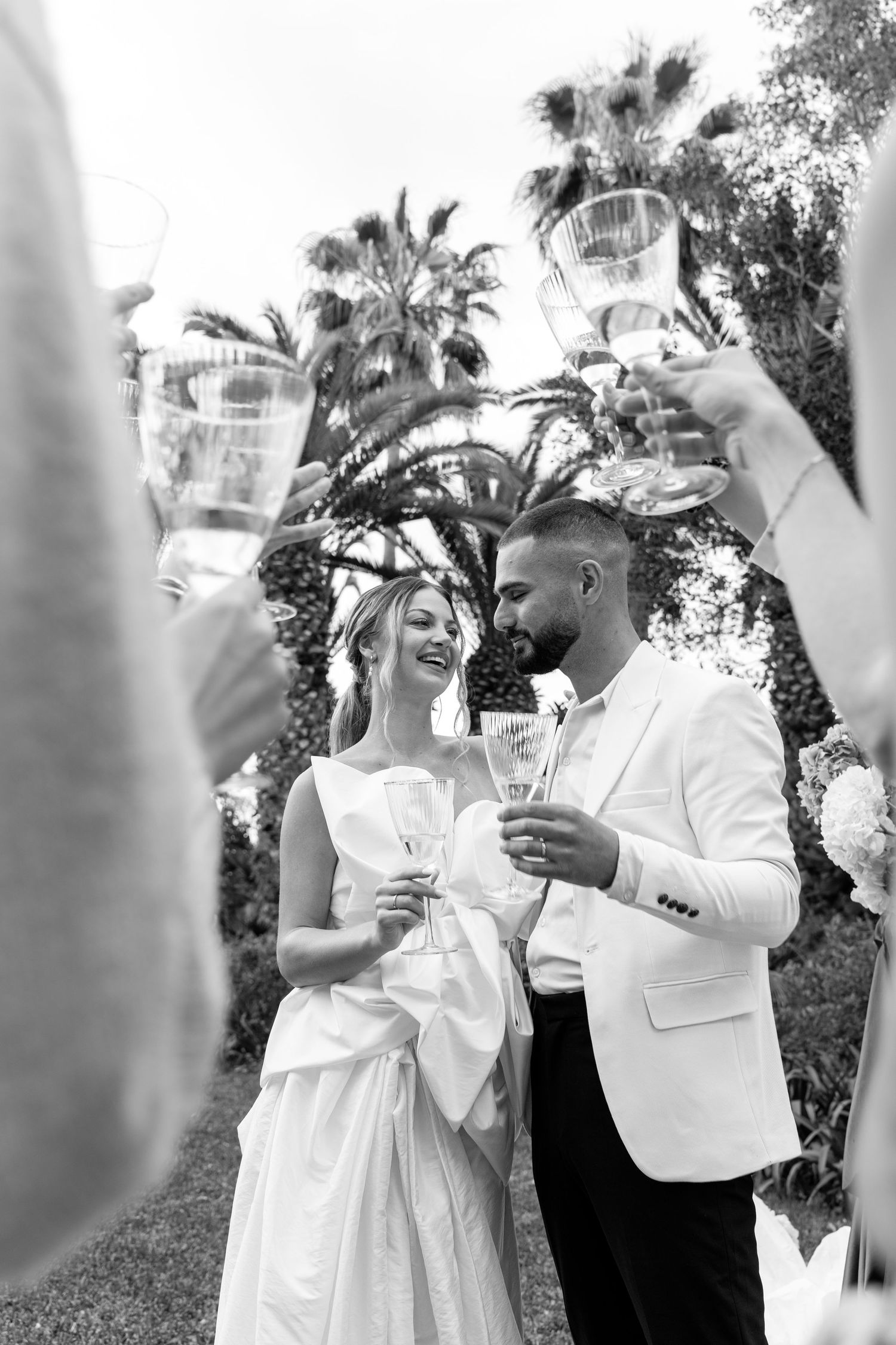 Celebration sequence showing guests in white raising champagne glasses for a toast.