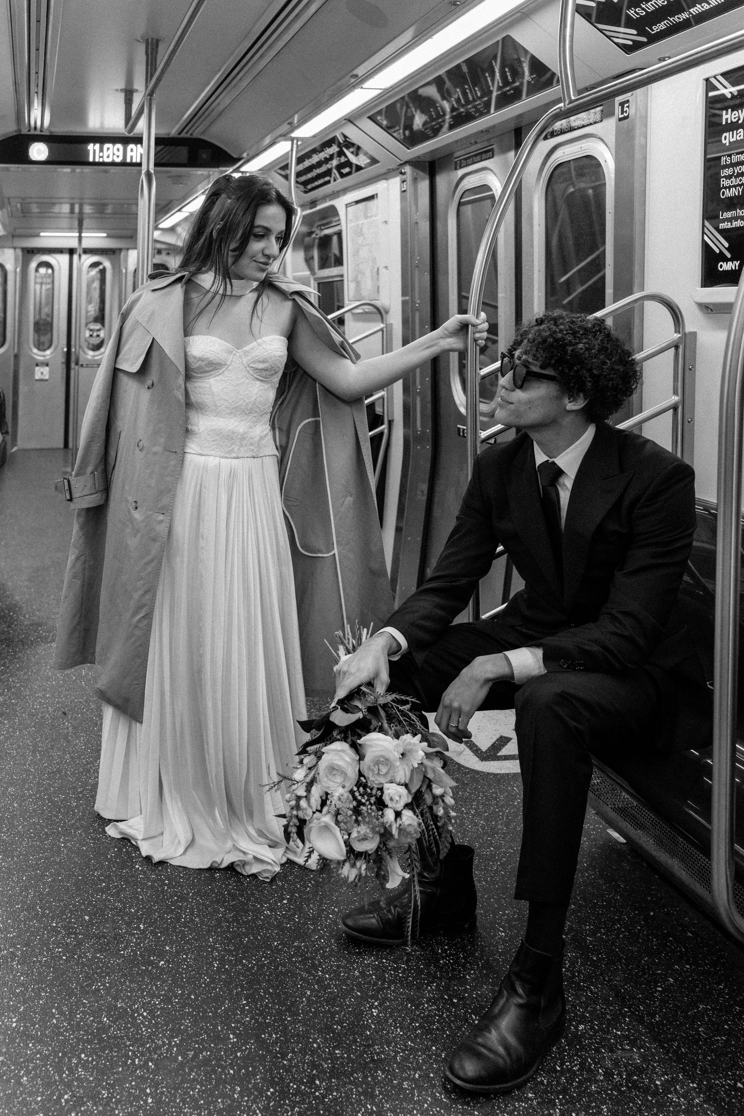 A playful wedding photo session on a subway train in black and white.
