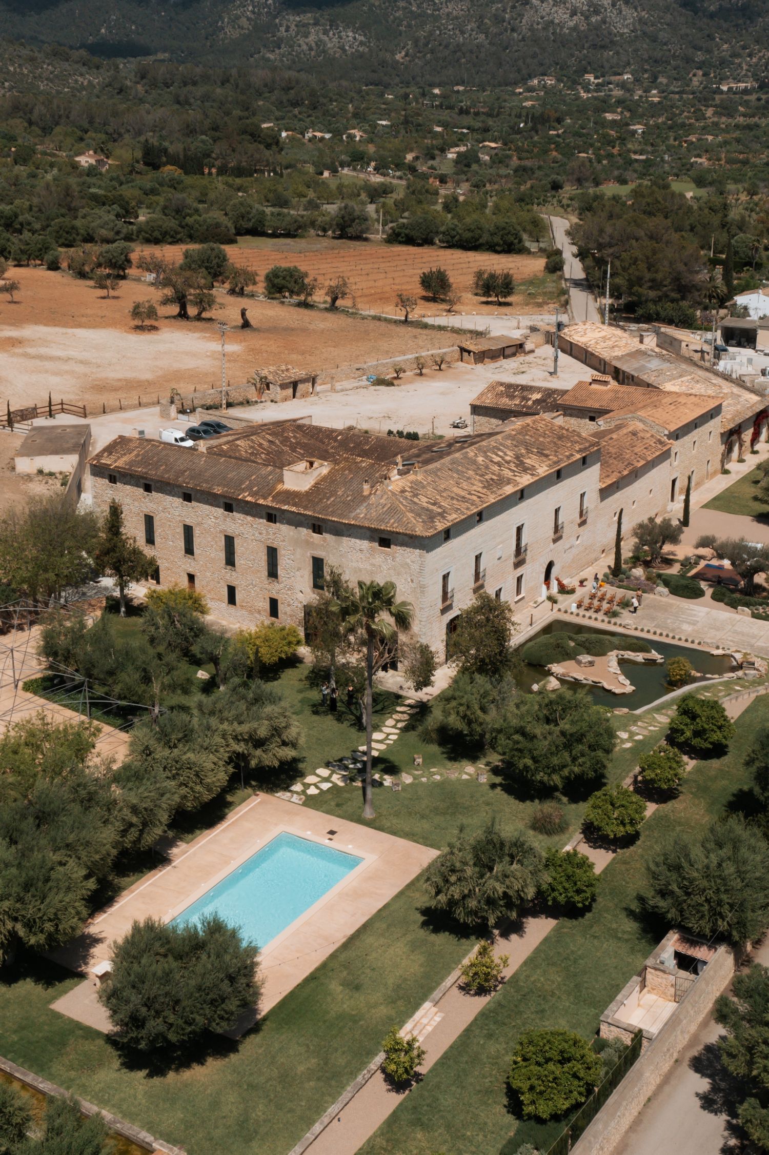 Aerial view of a luxurious Mediterranean villa with swimming pool and manicured gardens in rural setting.