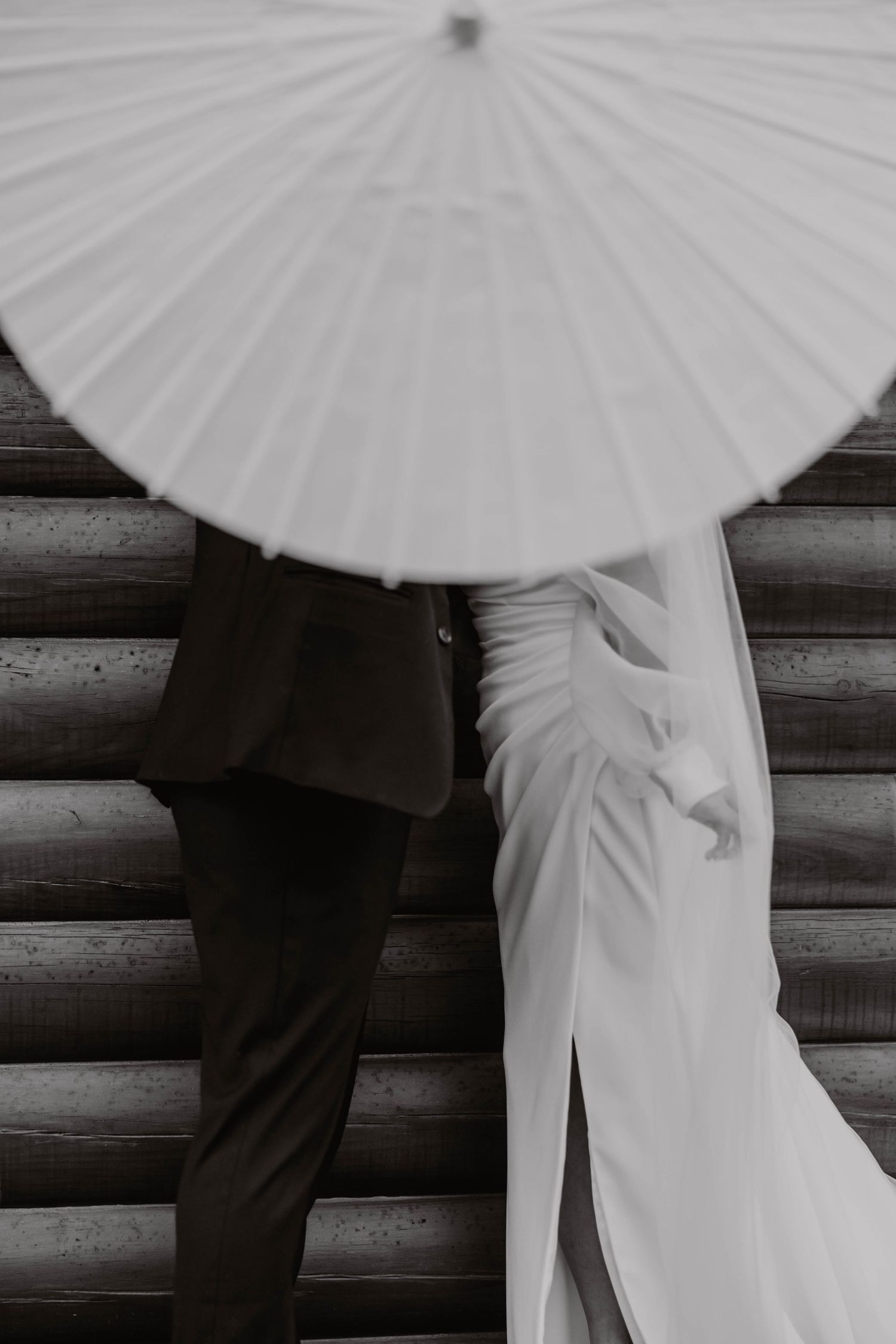 Artistic shots of formal attire beneath white parasol against wooden backdrop.
