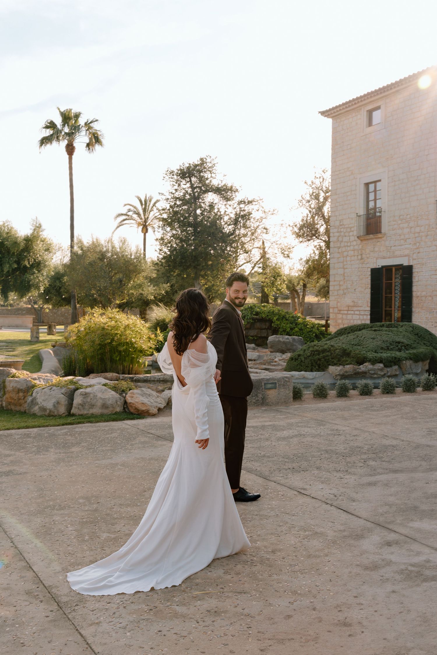 A romantic sunset wedding photo session outside a Mediterranean-style building.