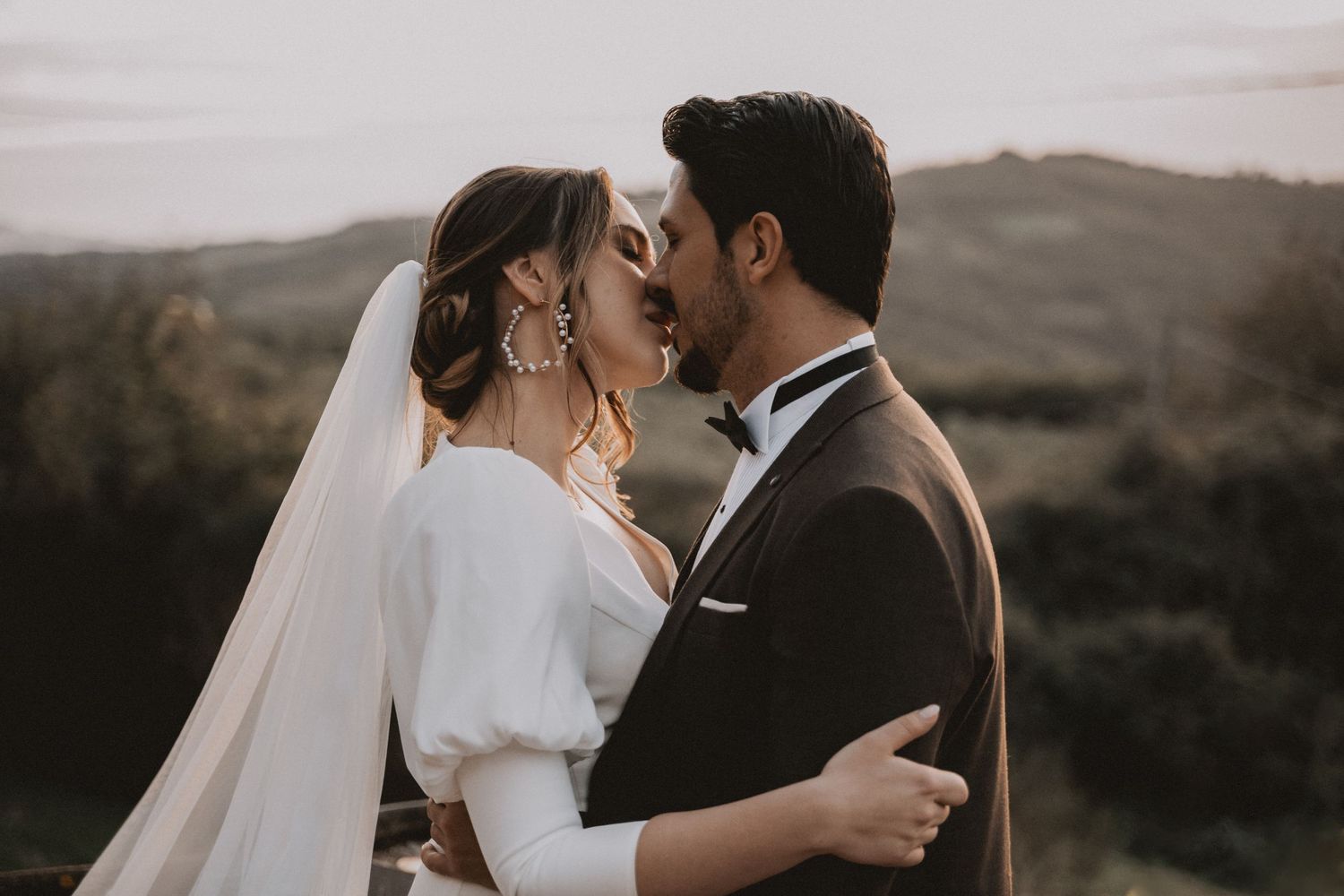 Romantic sunset moment between newlyweds in soft lighting.