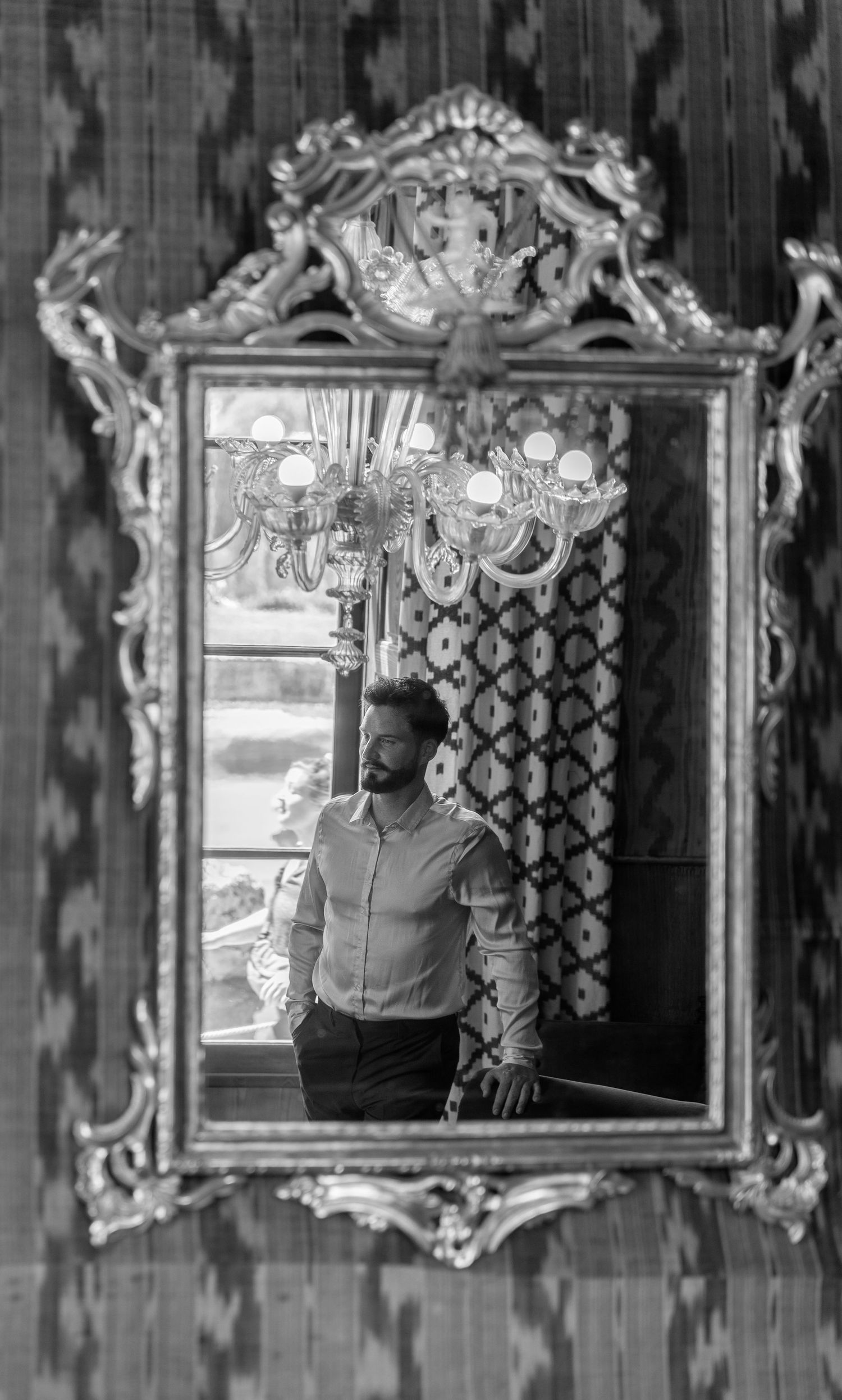 Vintage mirrors with ornate frames displayed in a row show reflections in black and white.