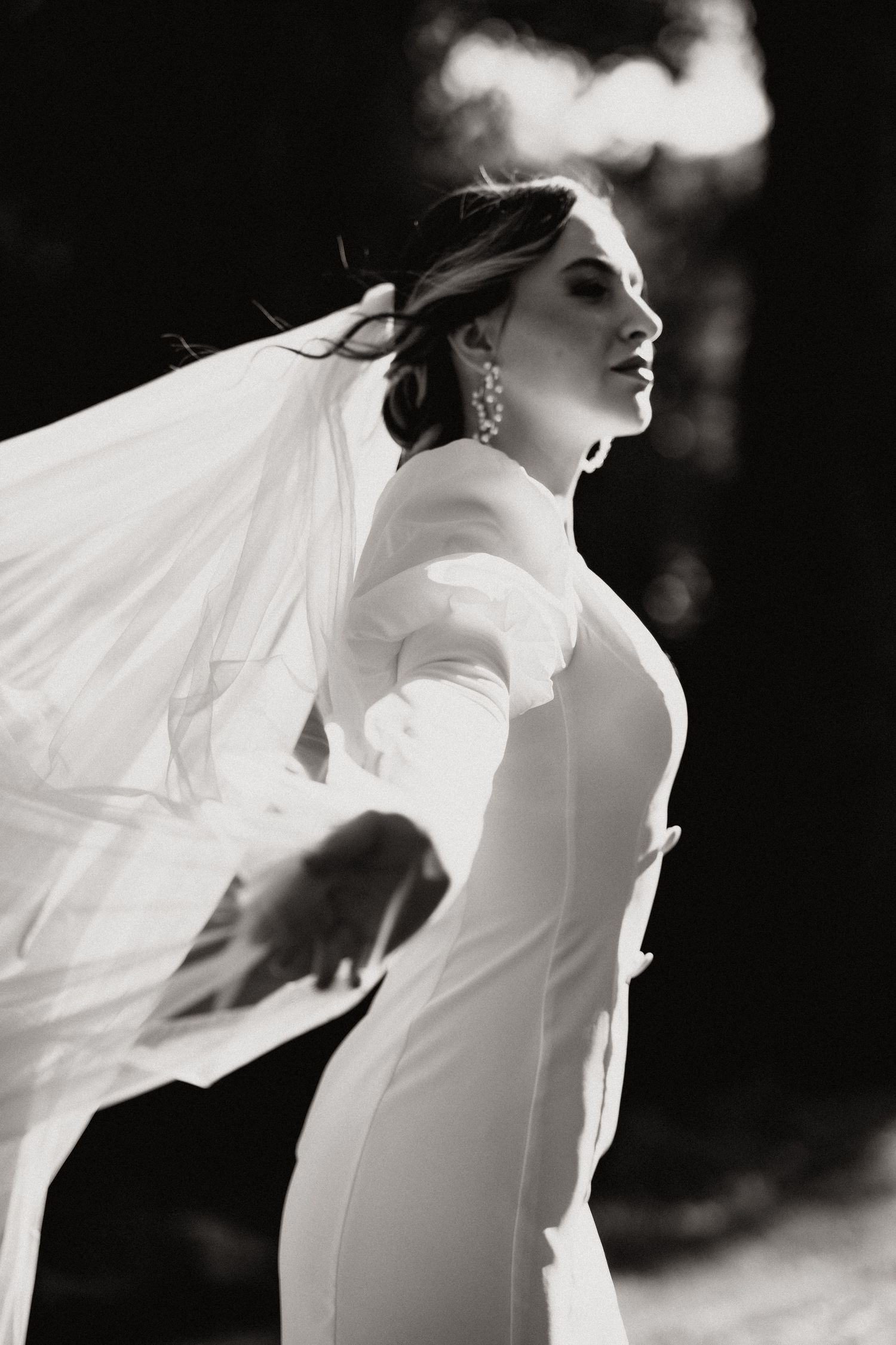 Artistic black and white portrait capturing flowing bridal veil movement.
