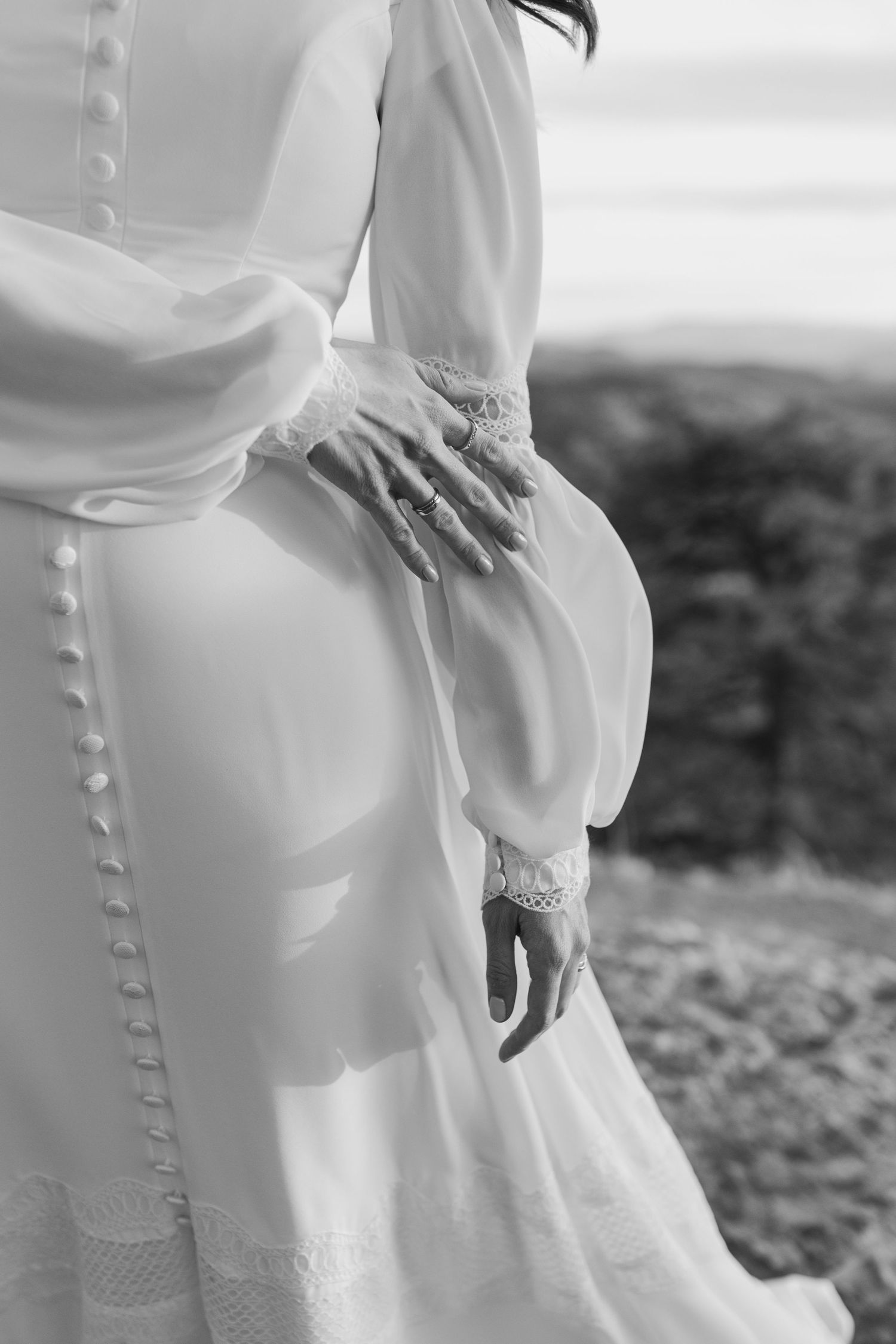 Detailed black and white view of a wedding dress with delicate button details and lace.
