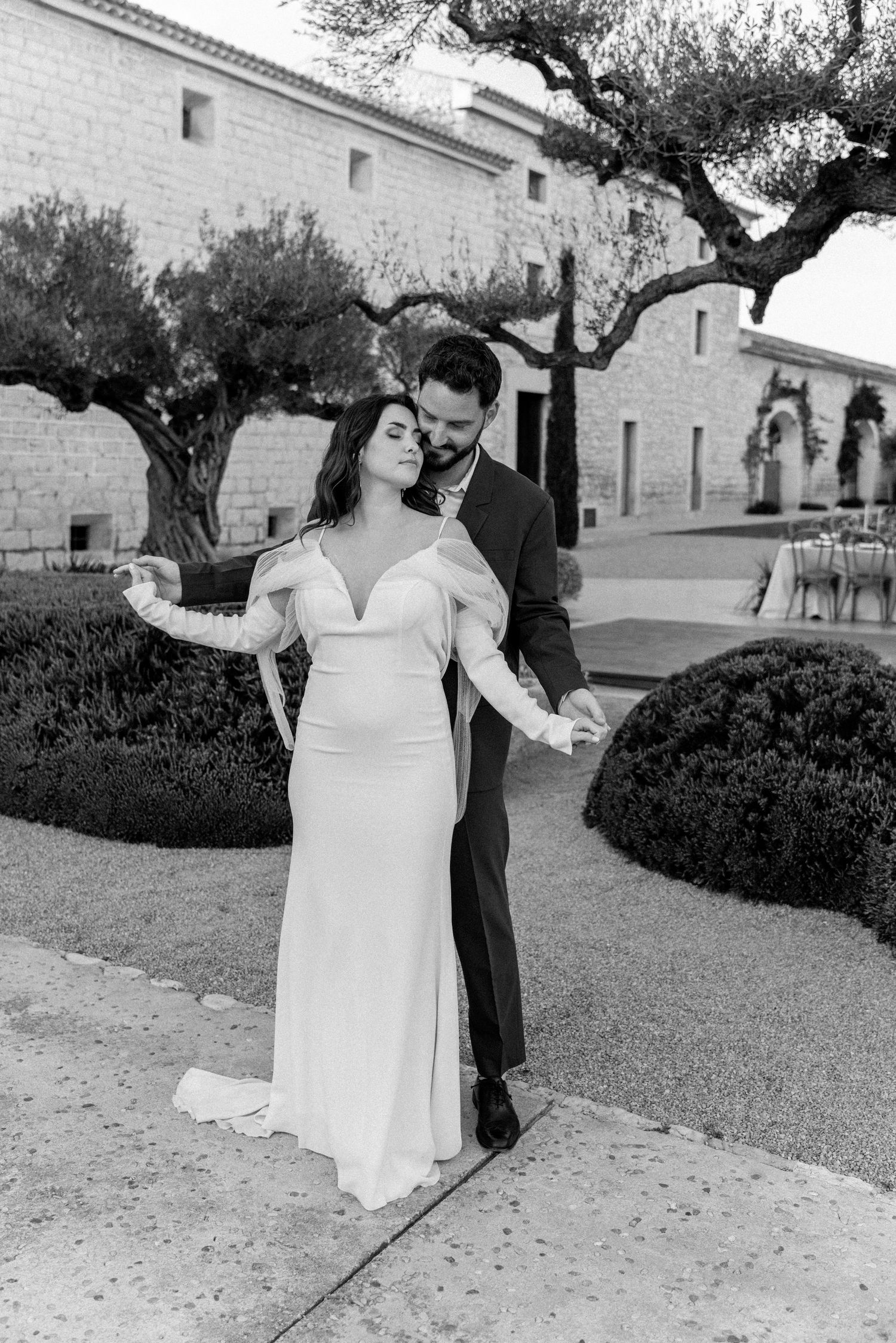 Romantic black and white wedding photos showing a couple dancing in an outdoor garden setting.
